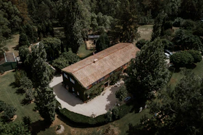 An aerial view of a house in the woods.