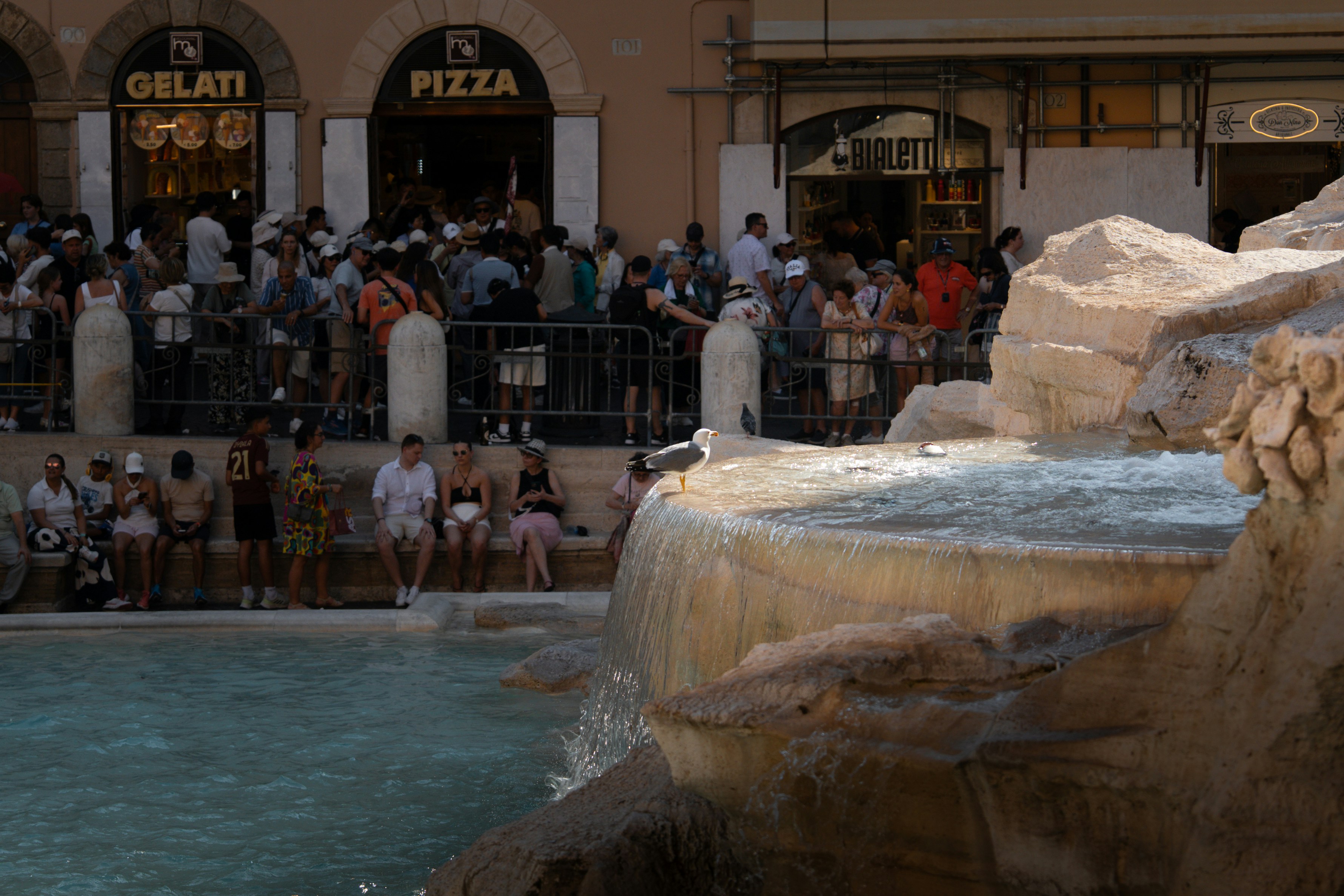 People gather around a fountain near food vendors.