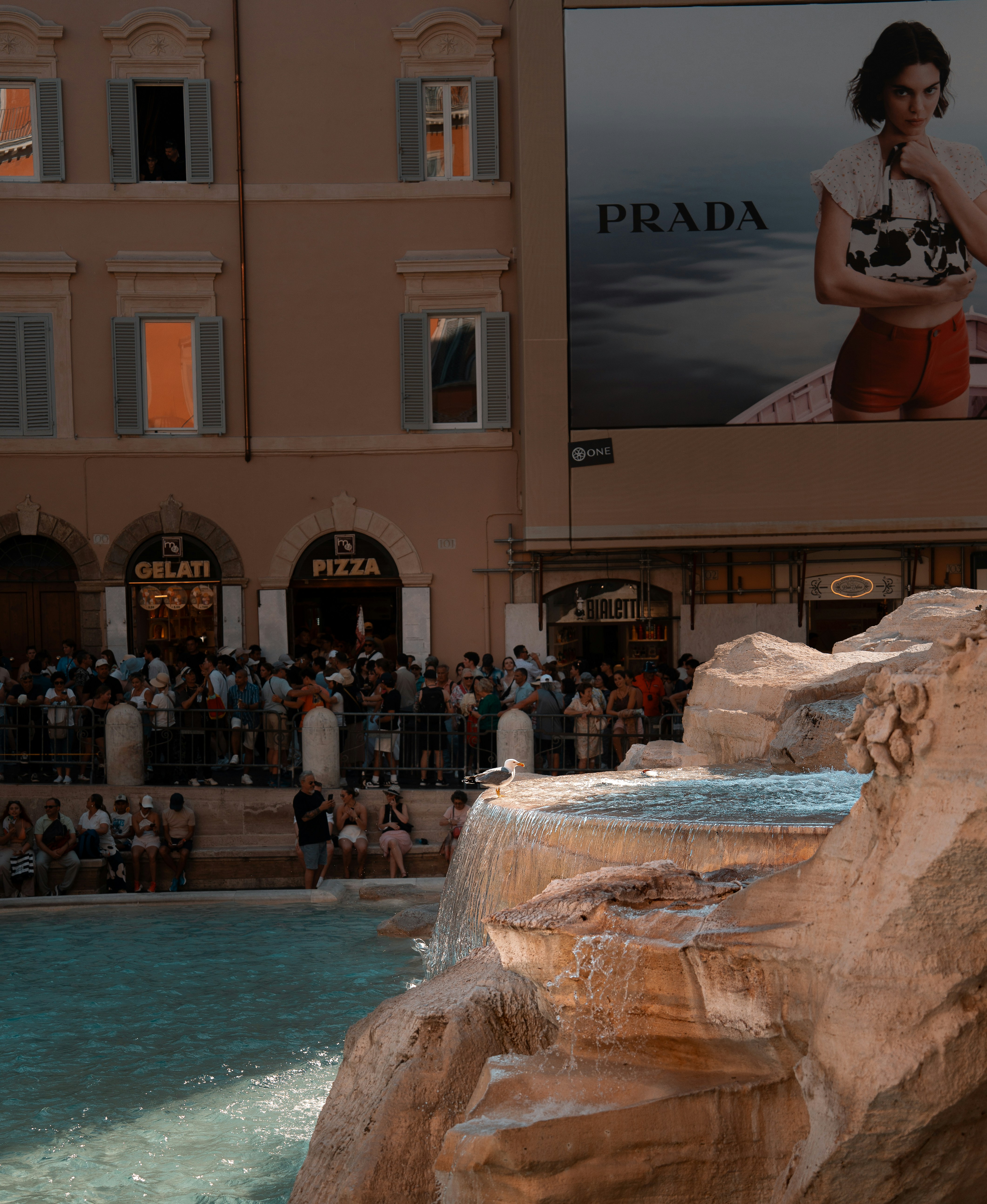 People crowd around the trevi fountain in rome.