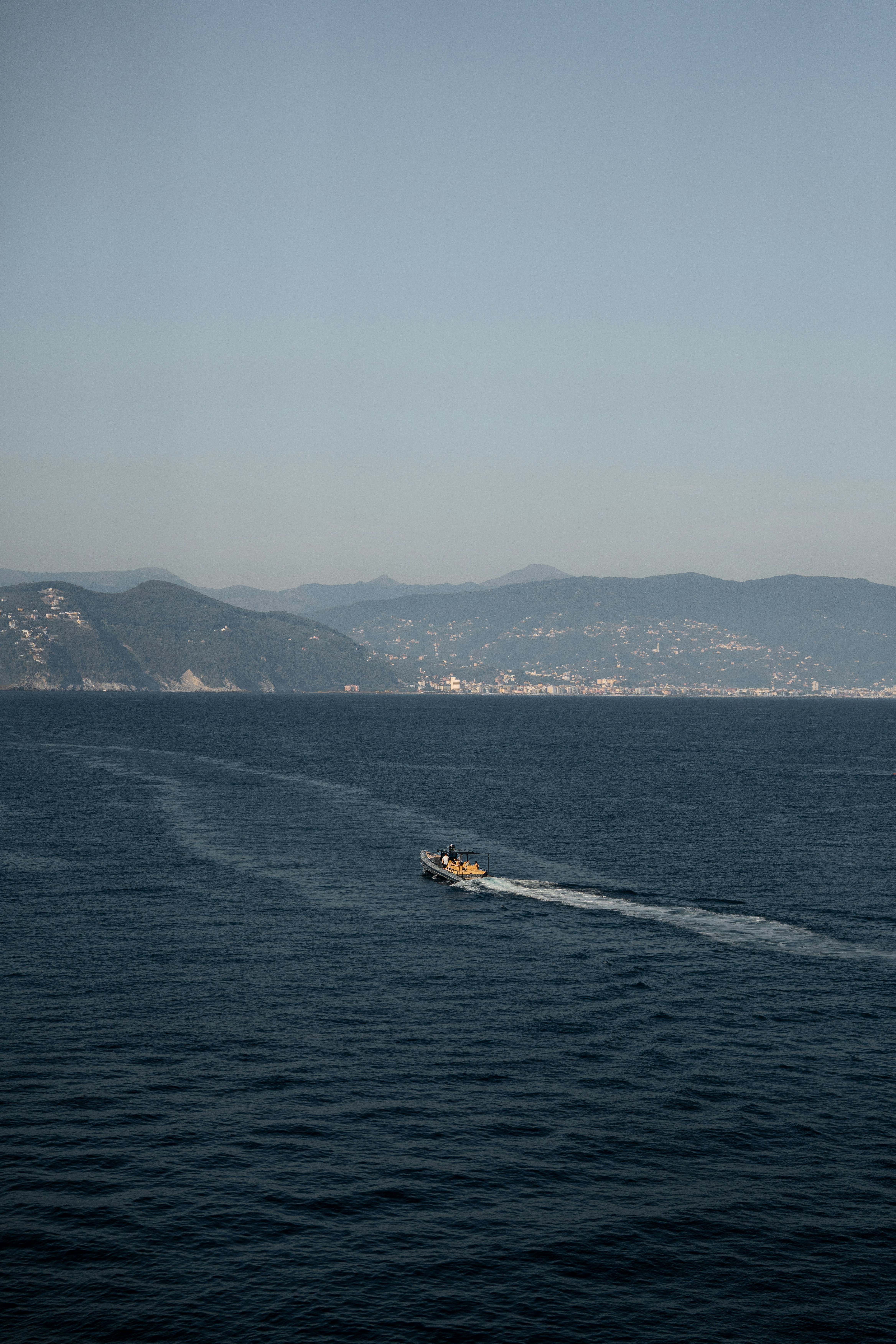 A boat travels across the blue ocean water.