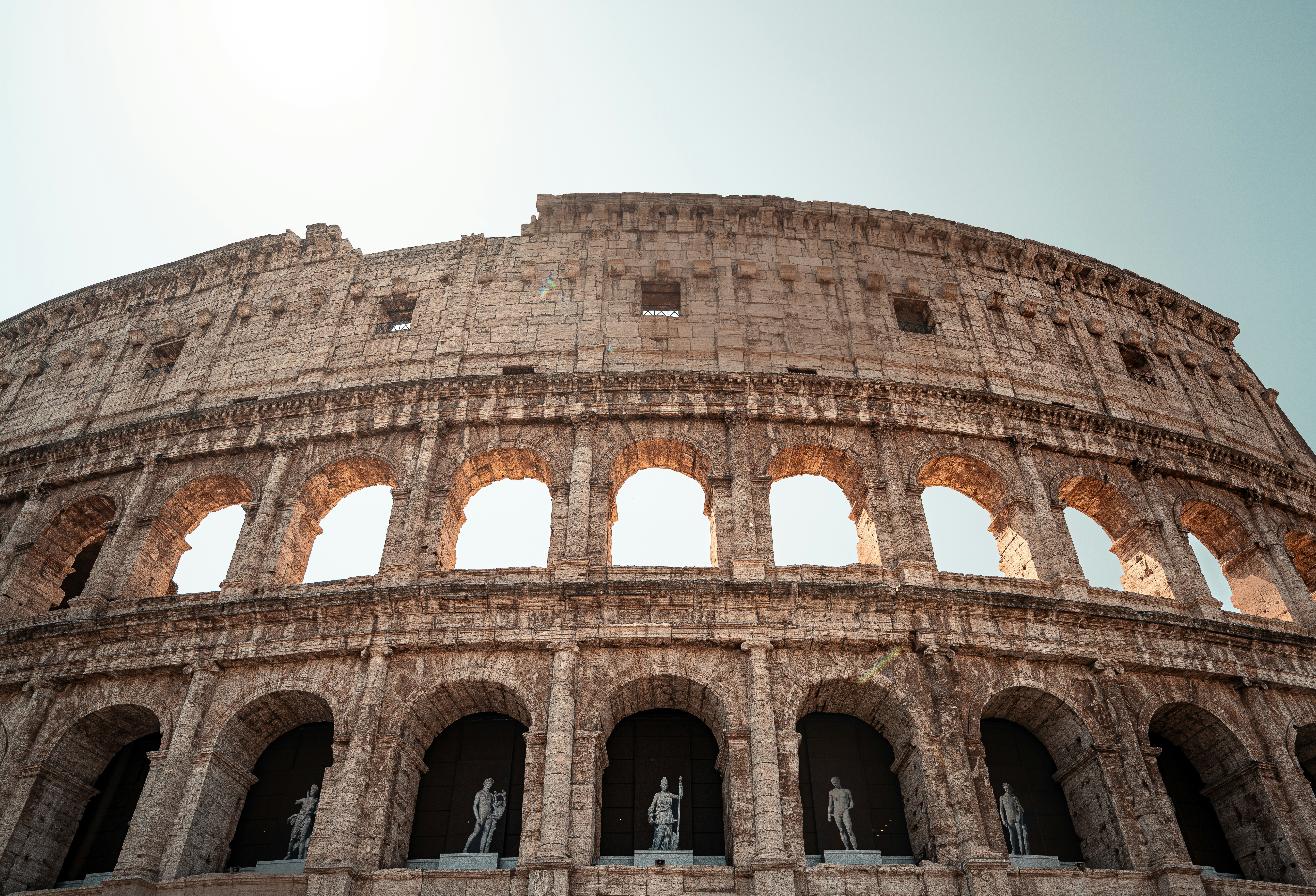 The colosseum stands proudly under a clear sky.