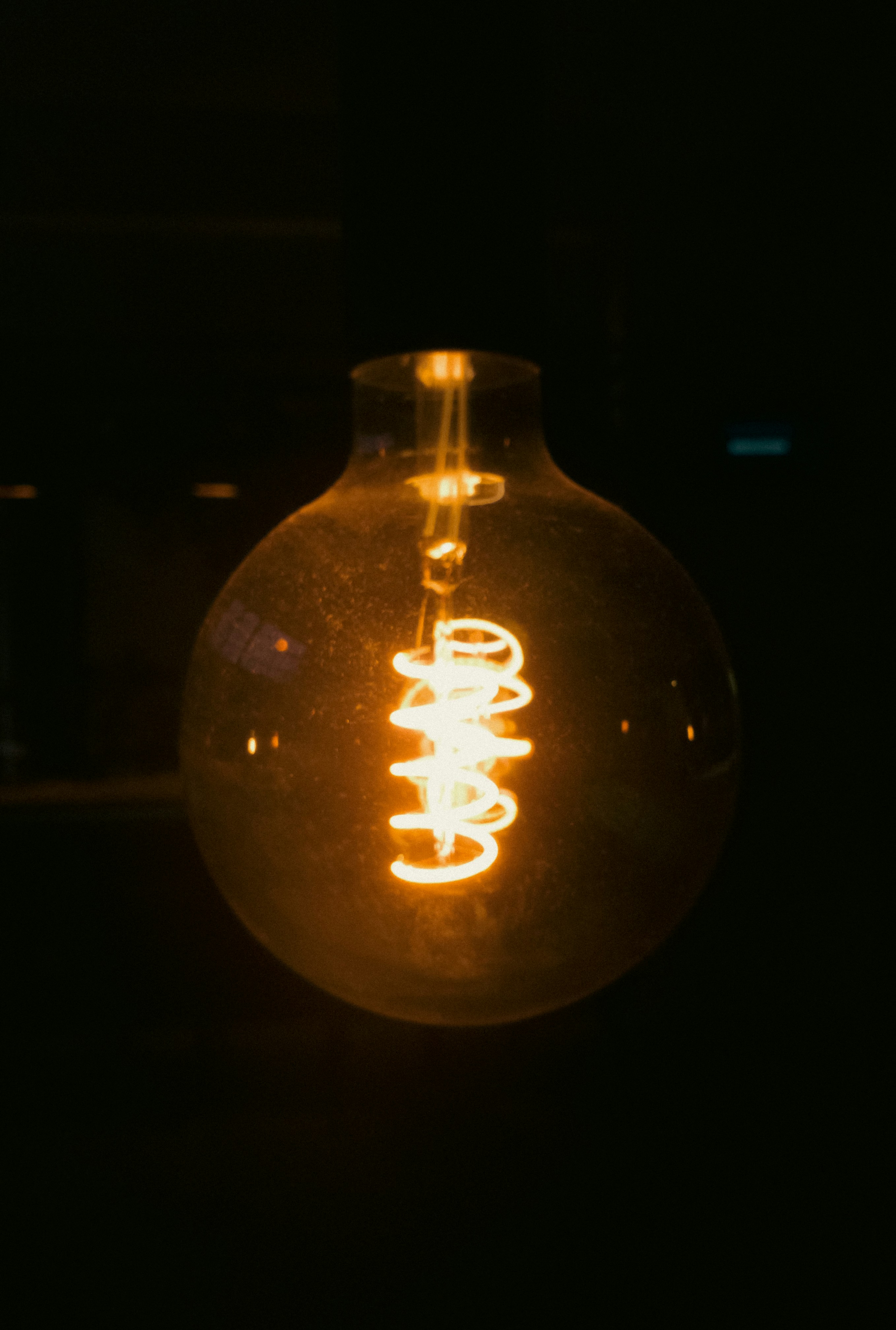 An incandescent bulb glows in the dark.