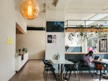 A modern cafe interior with people and plants.
