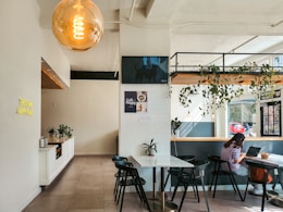 A modern cafe interior with people and plants.