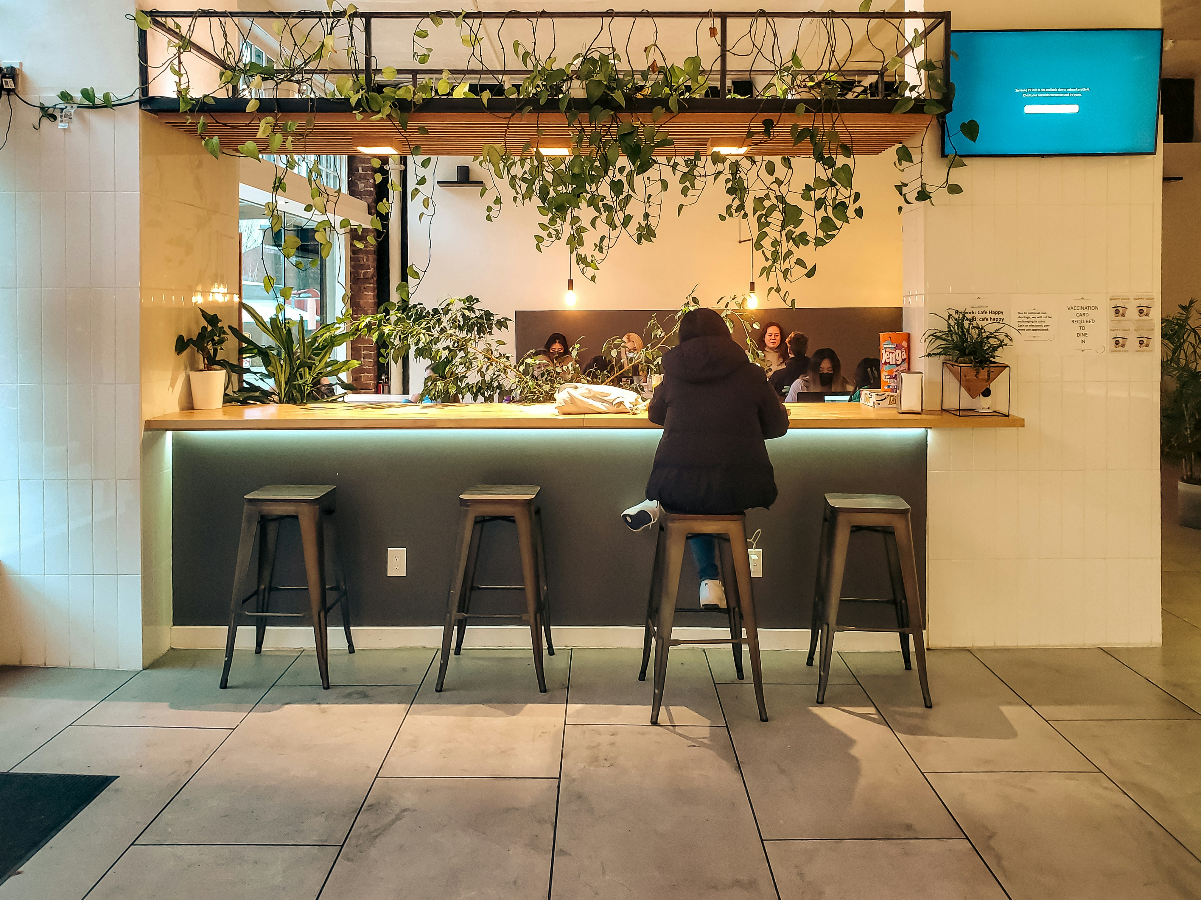 Eine Person sitzt an einer Theke in einem modernen Raum.