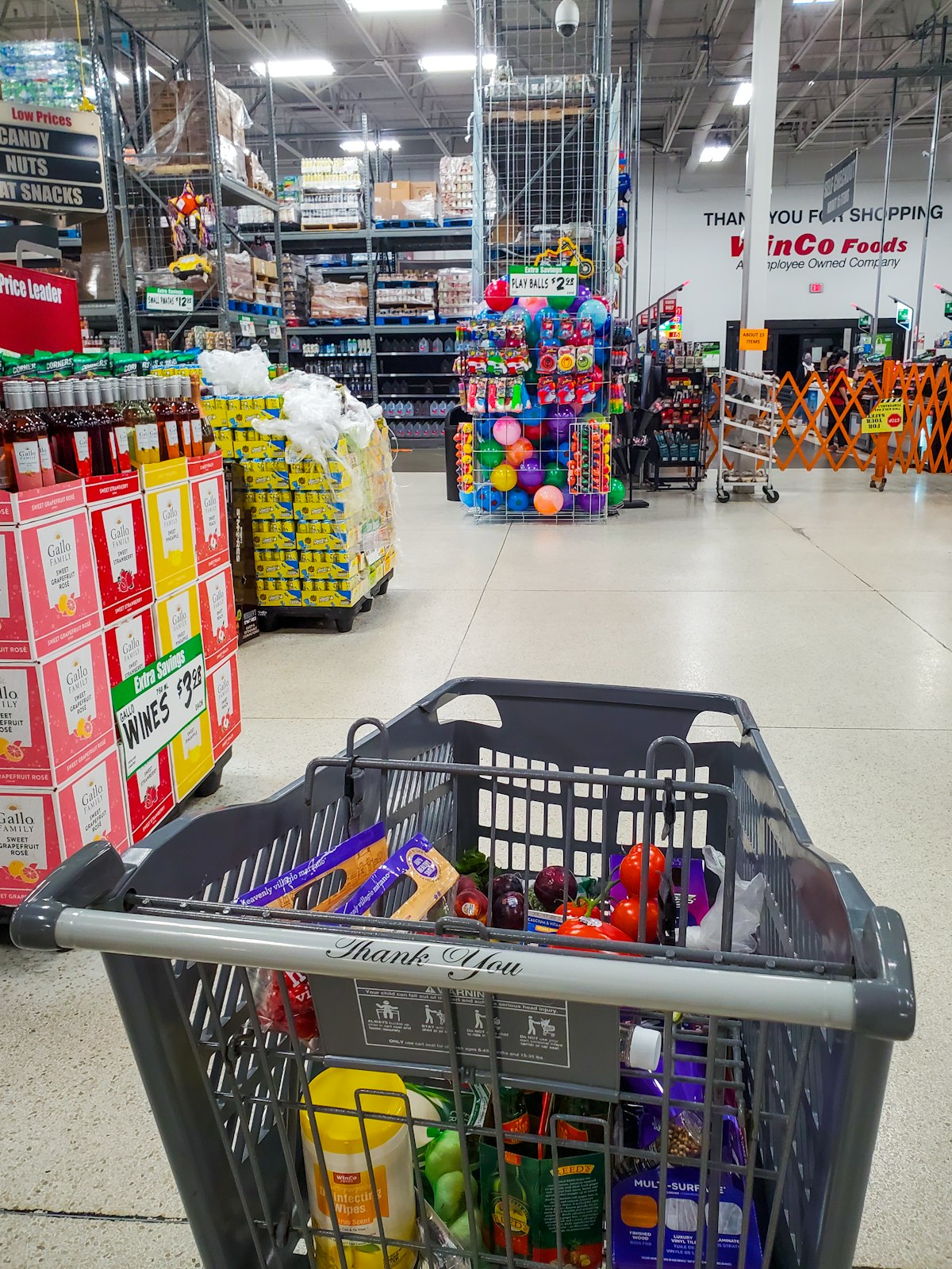 Shopping cart filled with goods in a large warehouse retail store