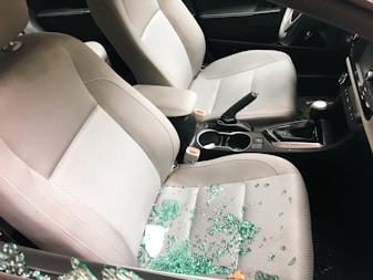 Car interior with shattered glass from a broken window.