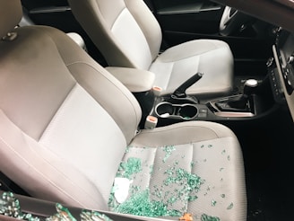Car interior with shattered glass from a broken window.