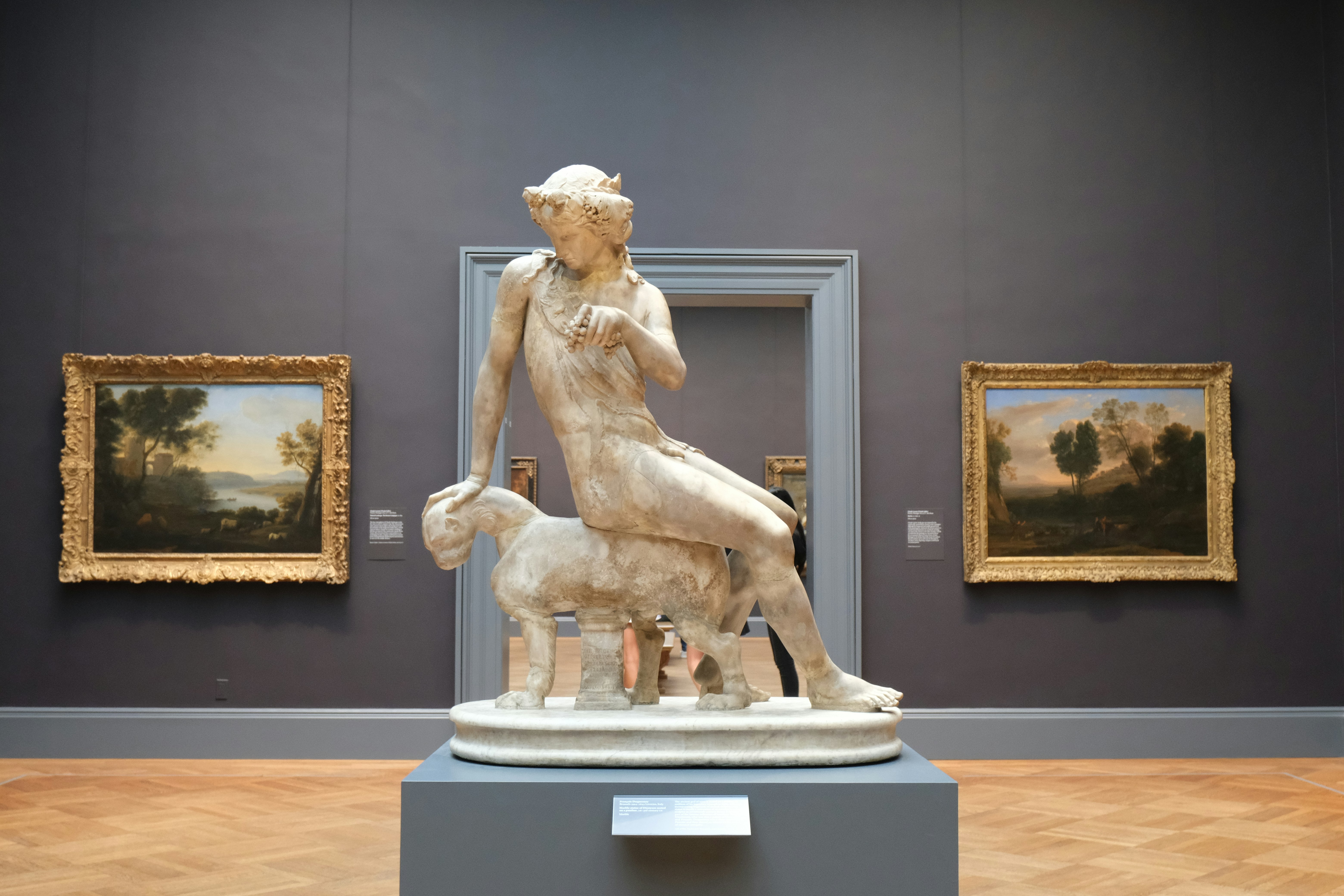 Marble statue sits in an art gallery.