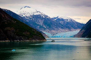 Mountains and glacier loom over the calm water.