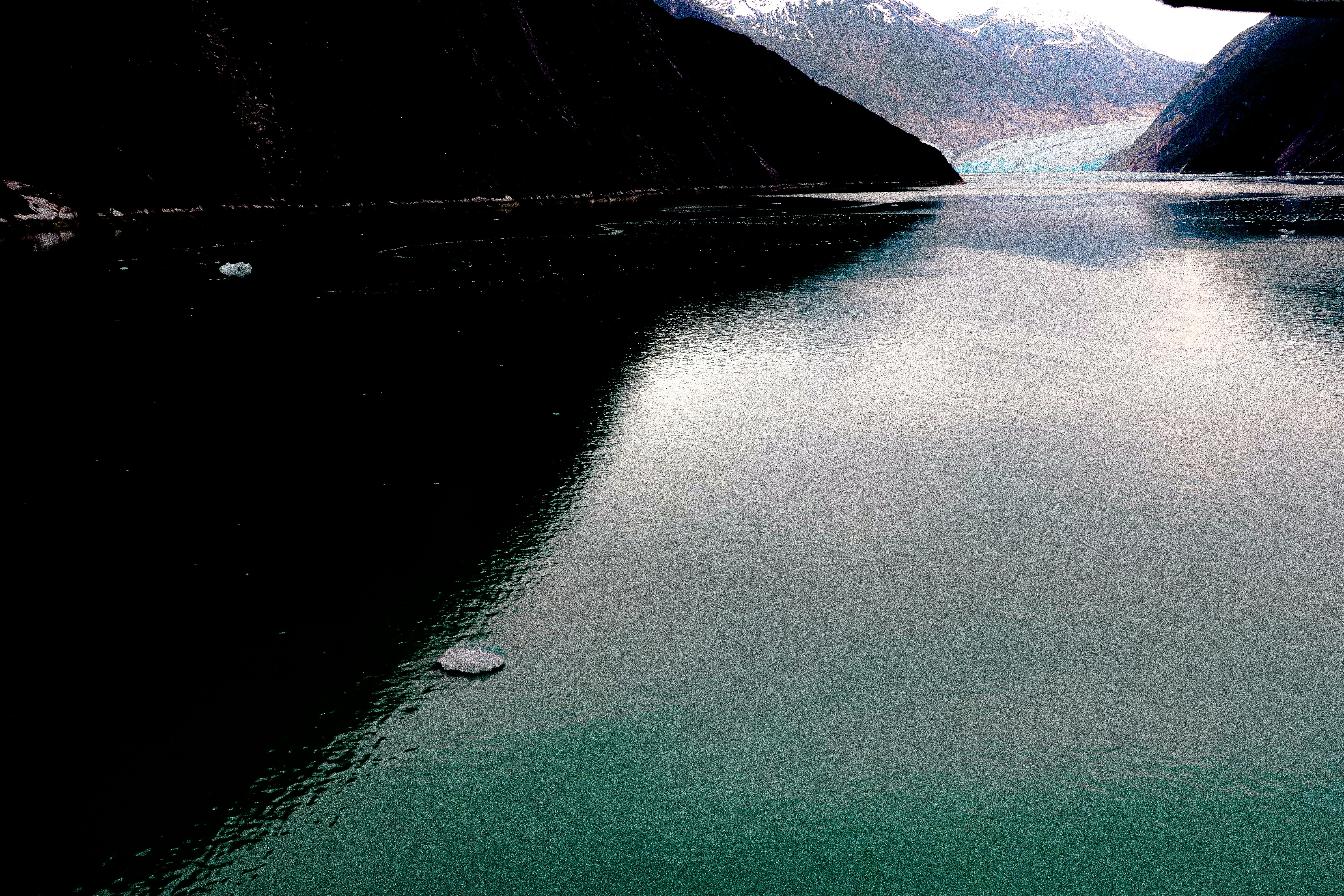 Calm, turquoise water reflects mountains and sky