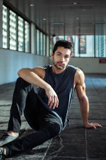 A handsome man poses in an urban setting.
