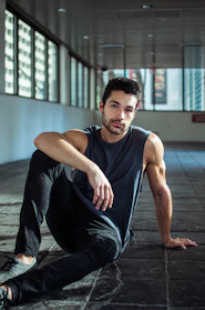 A handsome man poses in an urban setting.