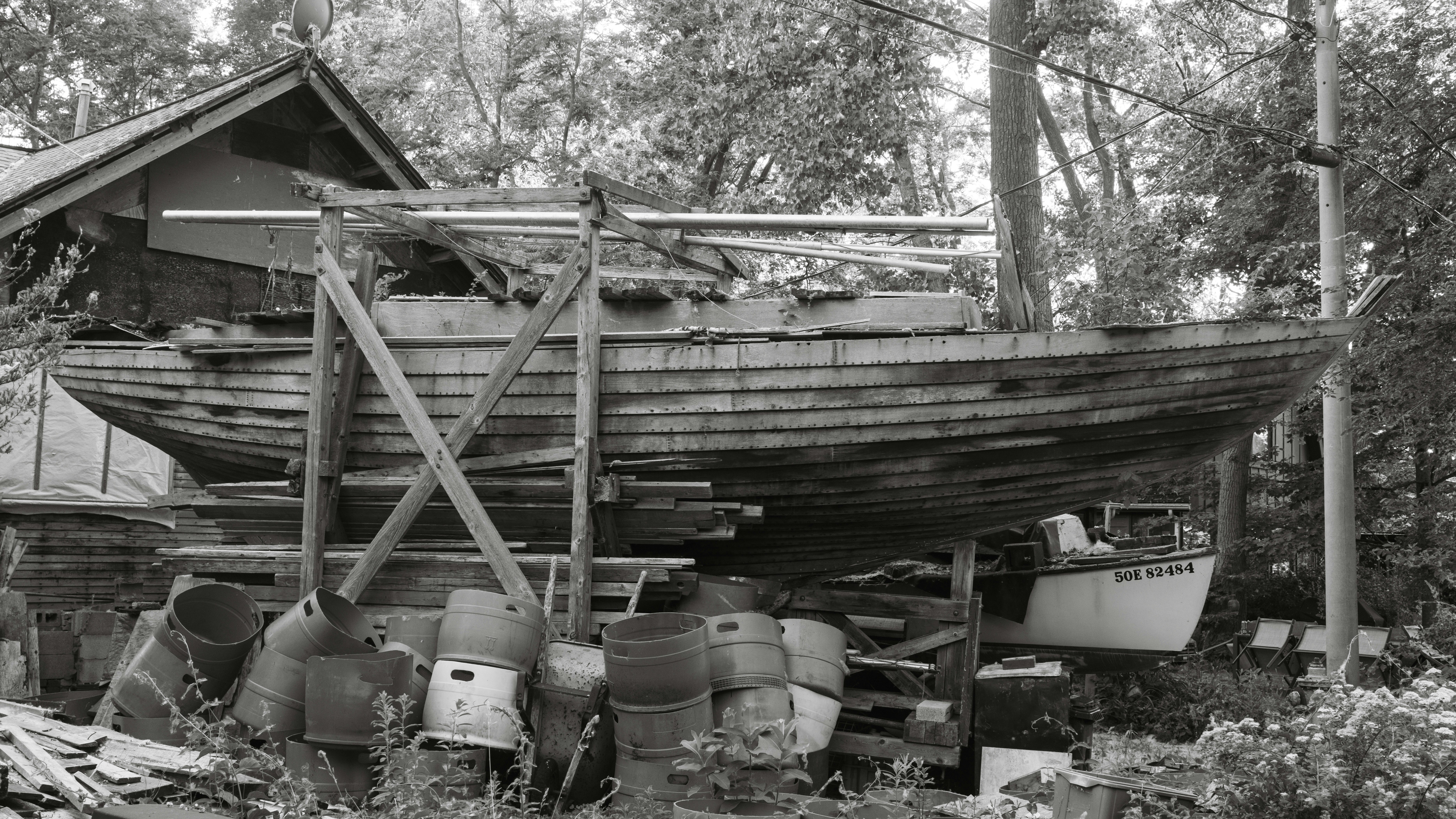 An old, weathered boat rests on wooden supports