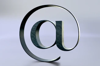 An at symbol is seen on a reflective surface