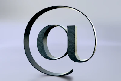 An at symbol is seen on a reflective surface