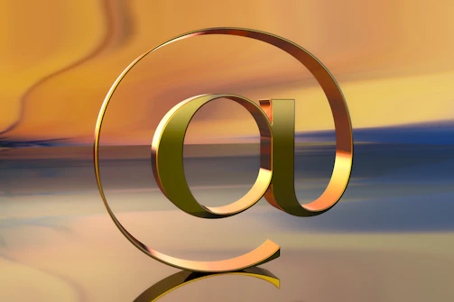 A golden @ symbol against a colorful backdrop