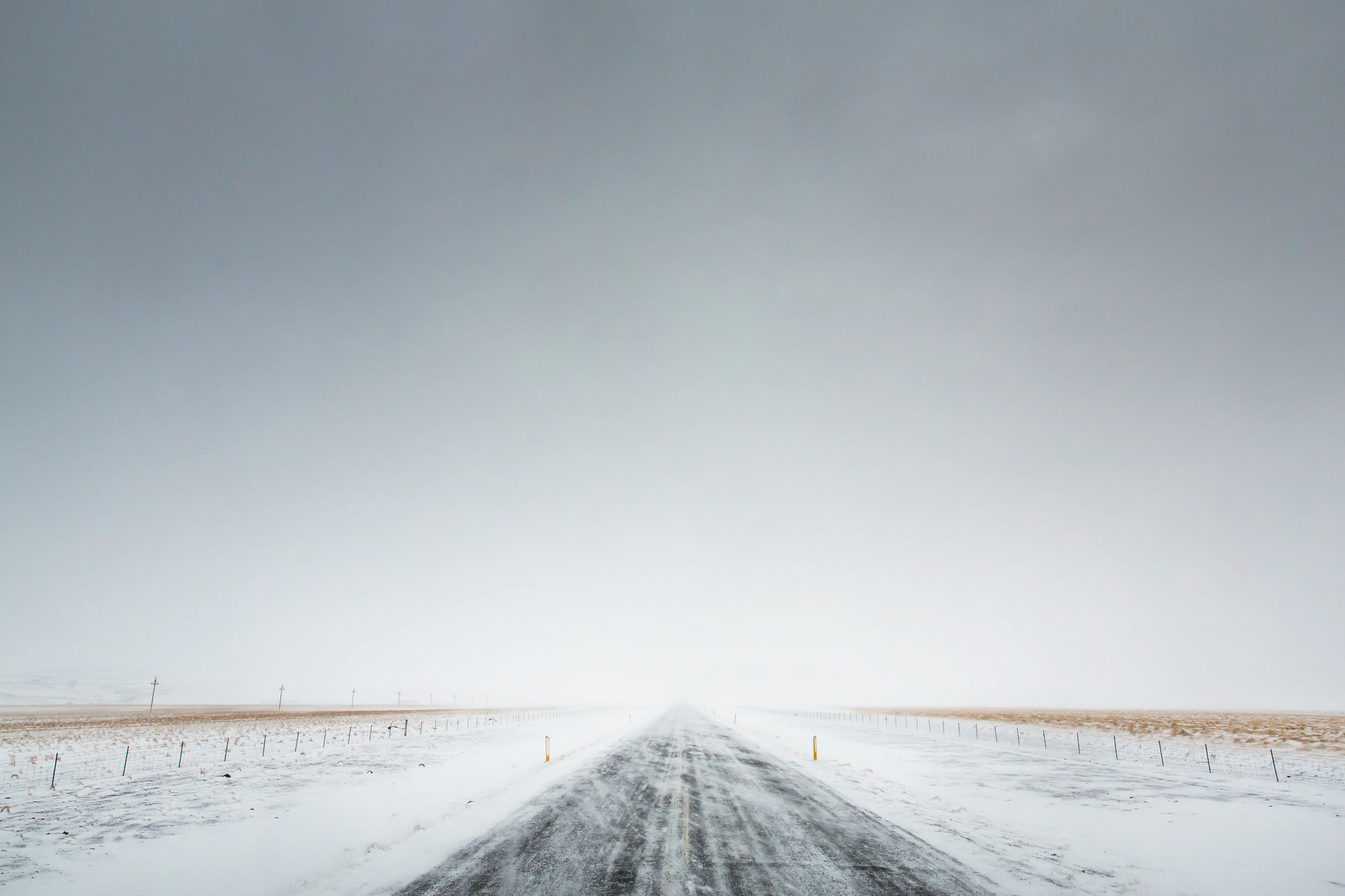 The snow-covered Route 1 towards Vík, fading into a pale winter haze