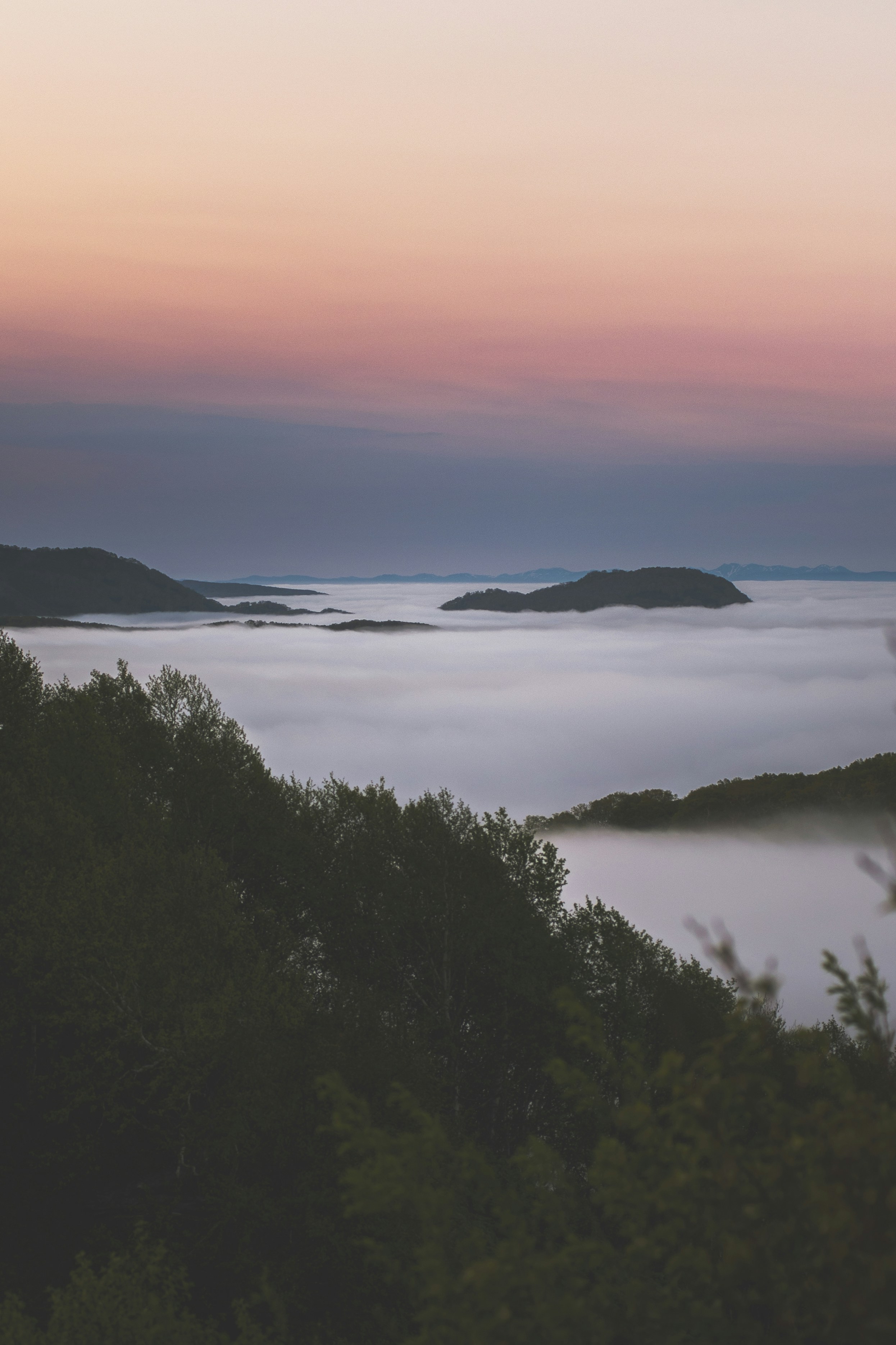 Mist blankets a valley at sunset.