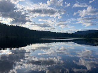 Reflections of clouds and sky on a calm lake.