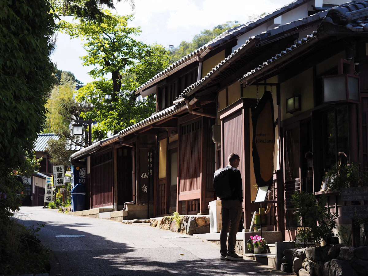 Traditional Tokyo neighborhood street with wooden buildings and lone figure walking