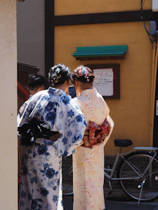 Two women in yukata look at something.
