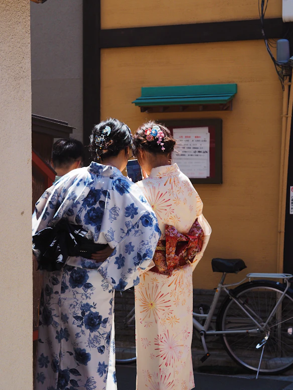Two women in yukata look at something.