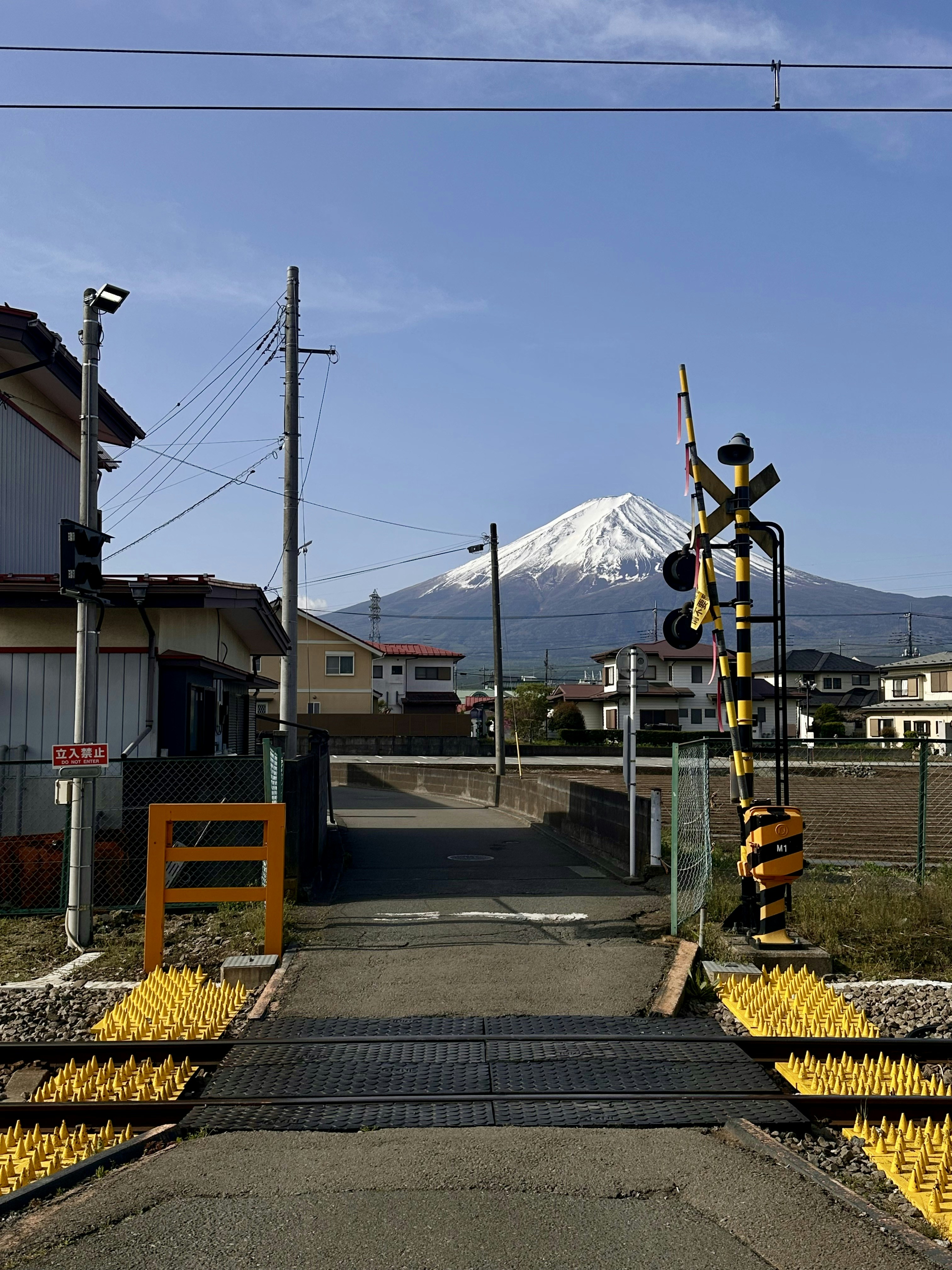 Un passaggio a livello con il monte fuji in lontananza.