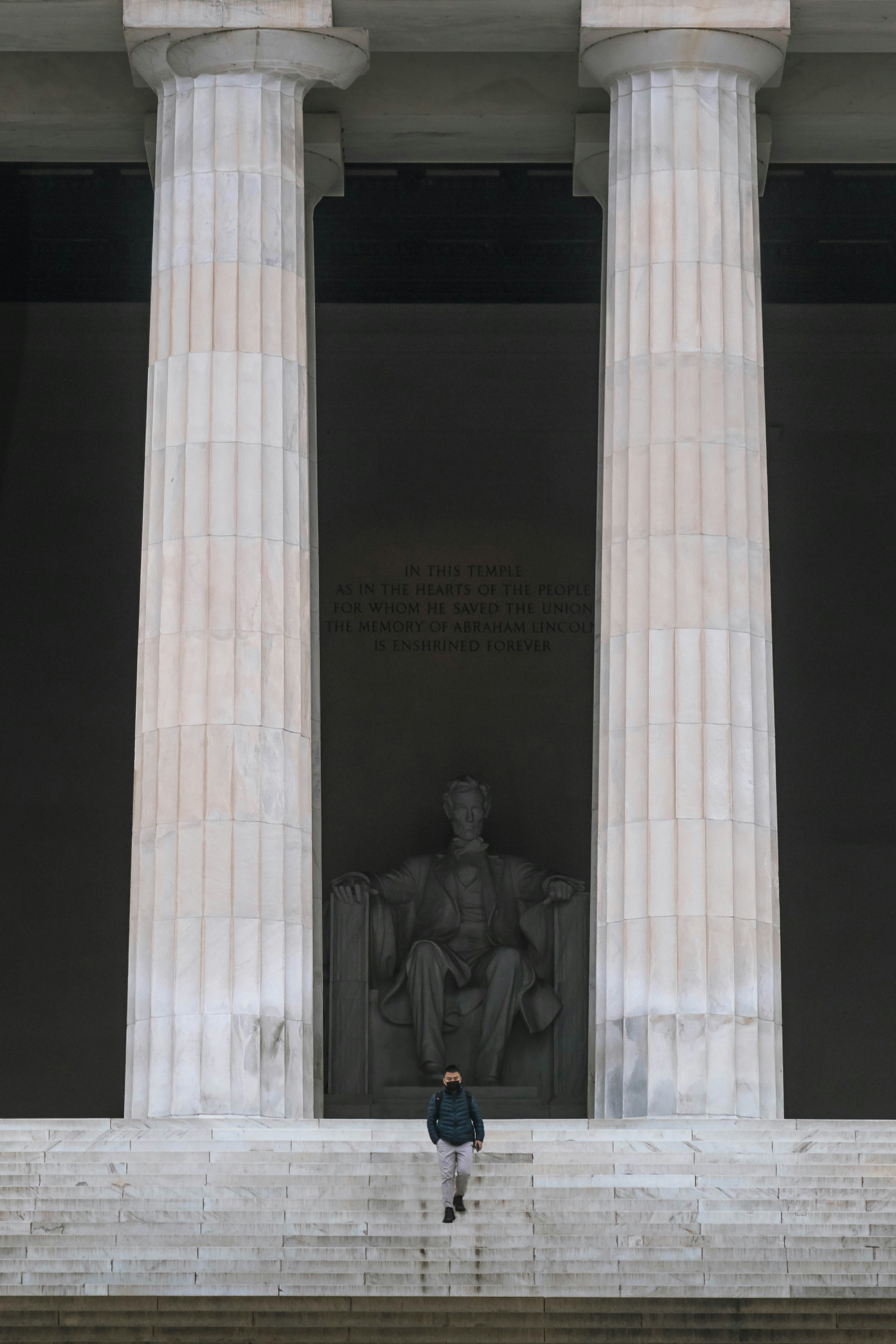 A person climbs steps toward the lincoln memorial.