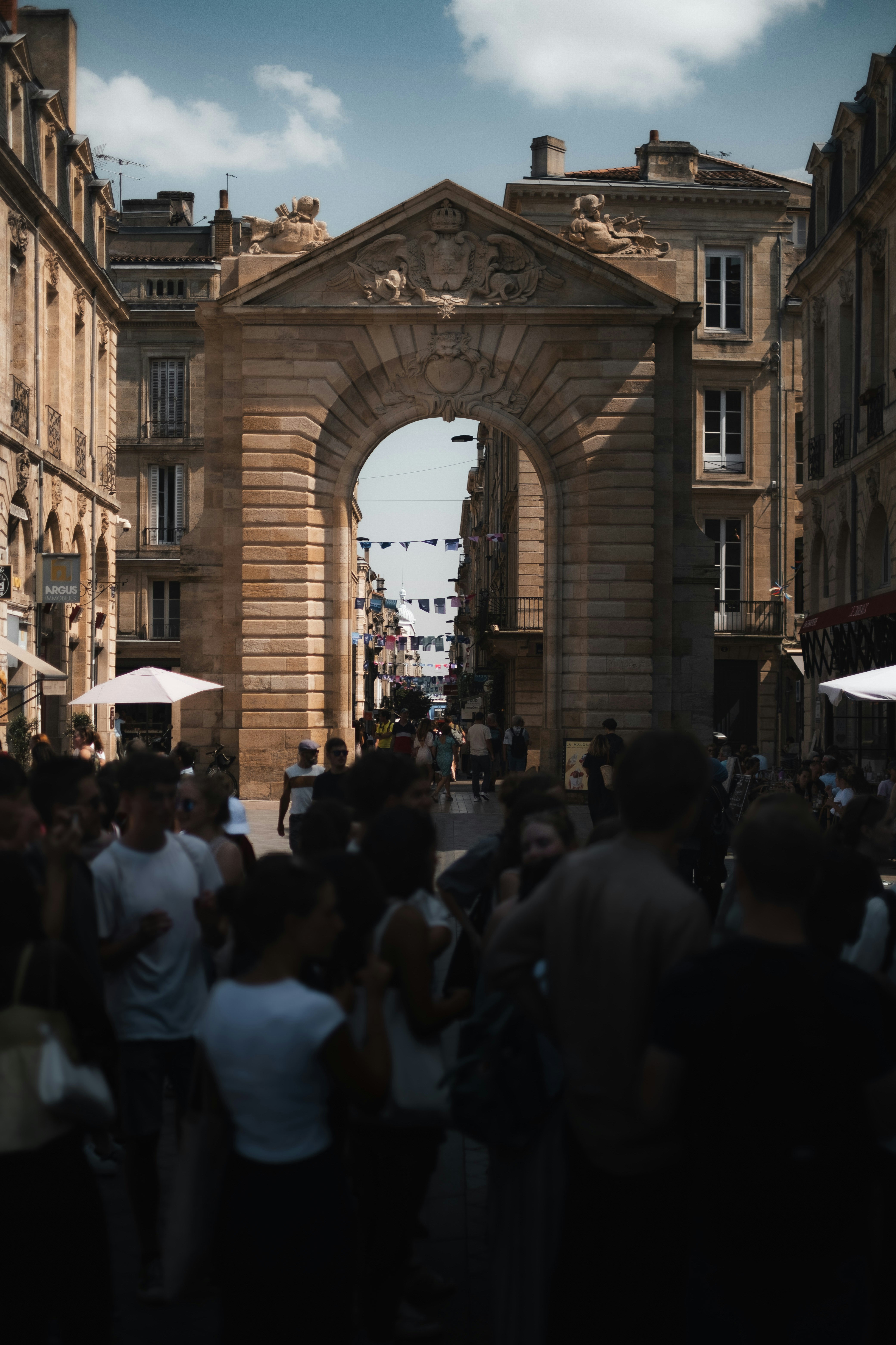 People gather beneath a large stone archway.
