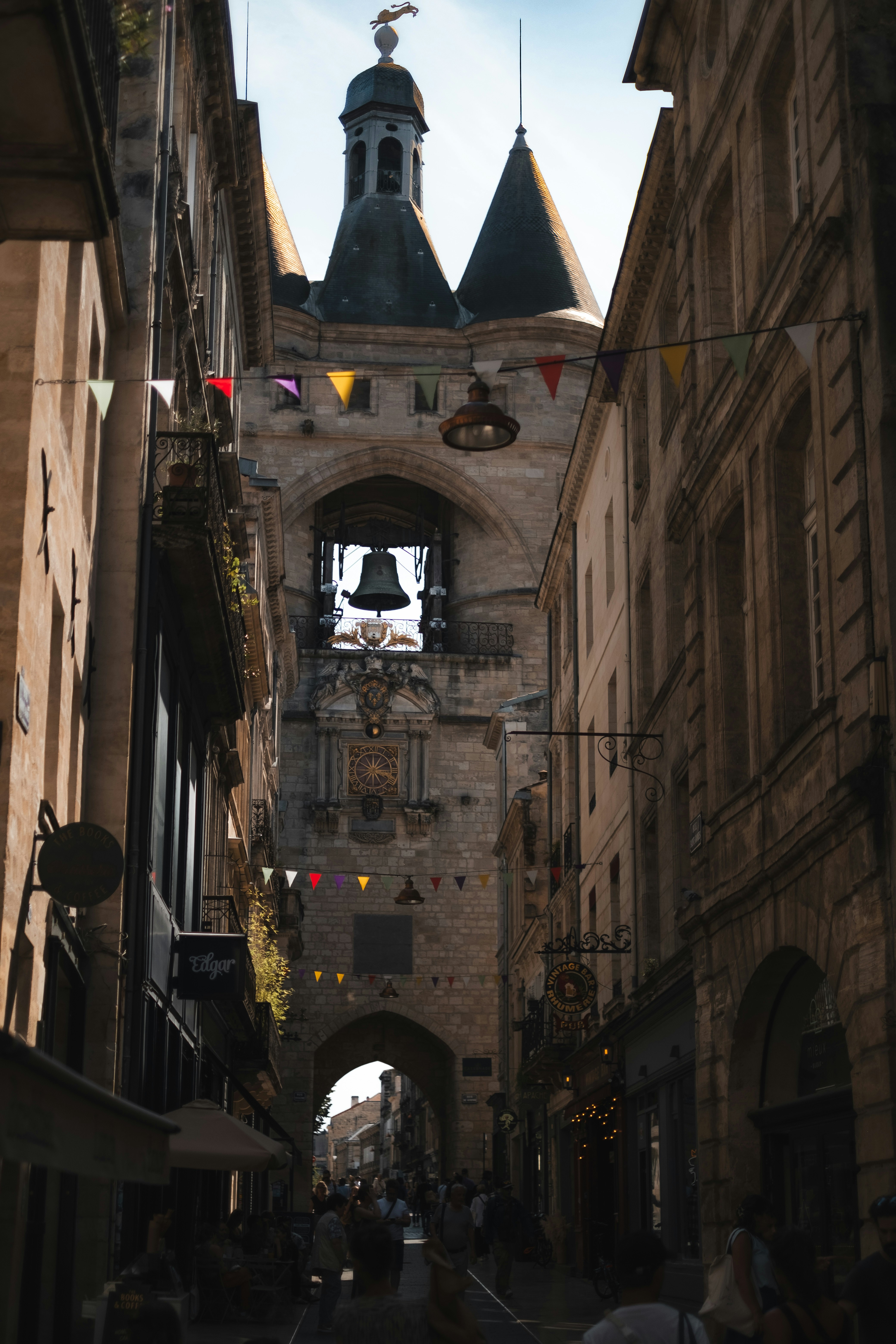 A narrow street leads to a historic clock tower.