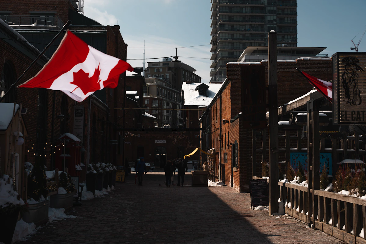Flags and historic brick buildings along a street in Toronto's Distillery District