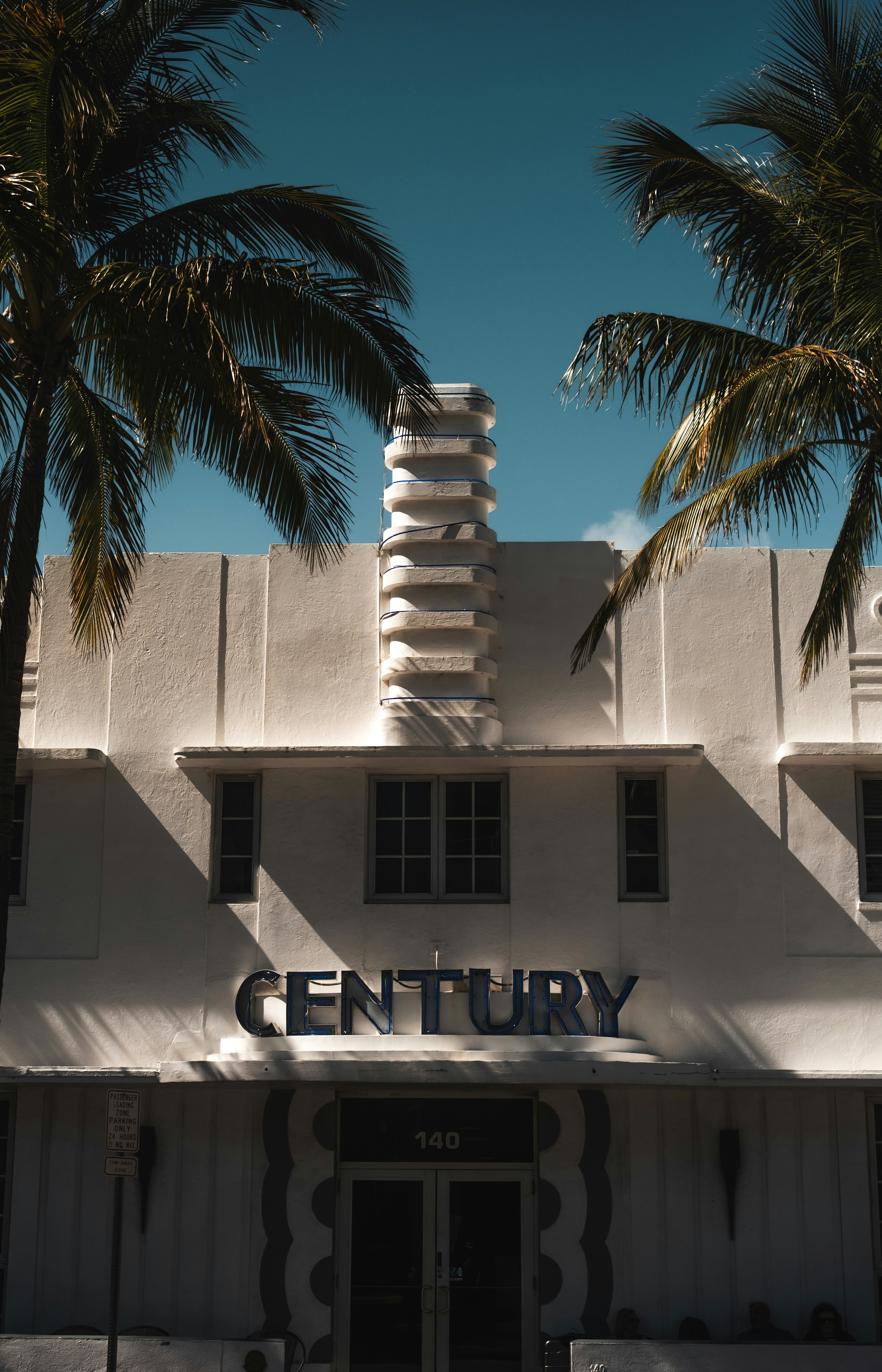 Palm trees frame the facade of the century building.