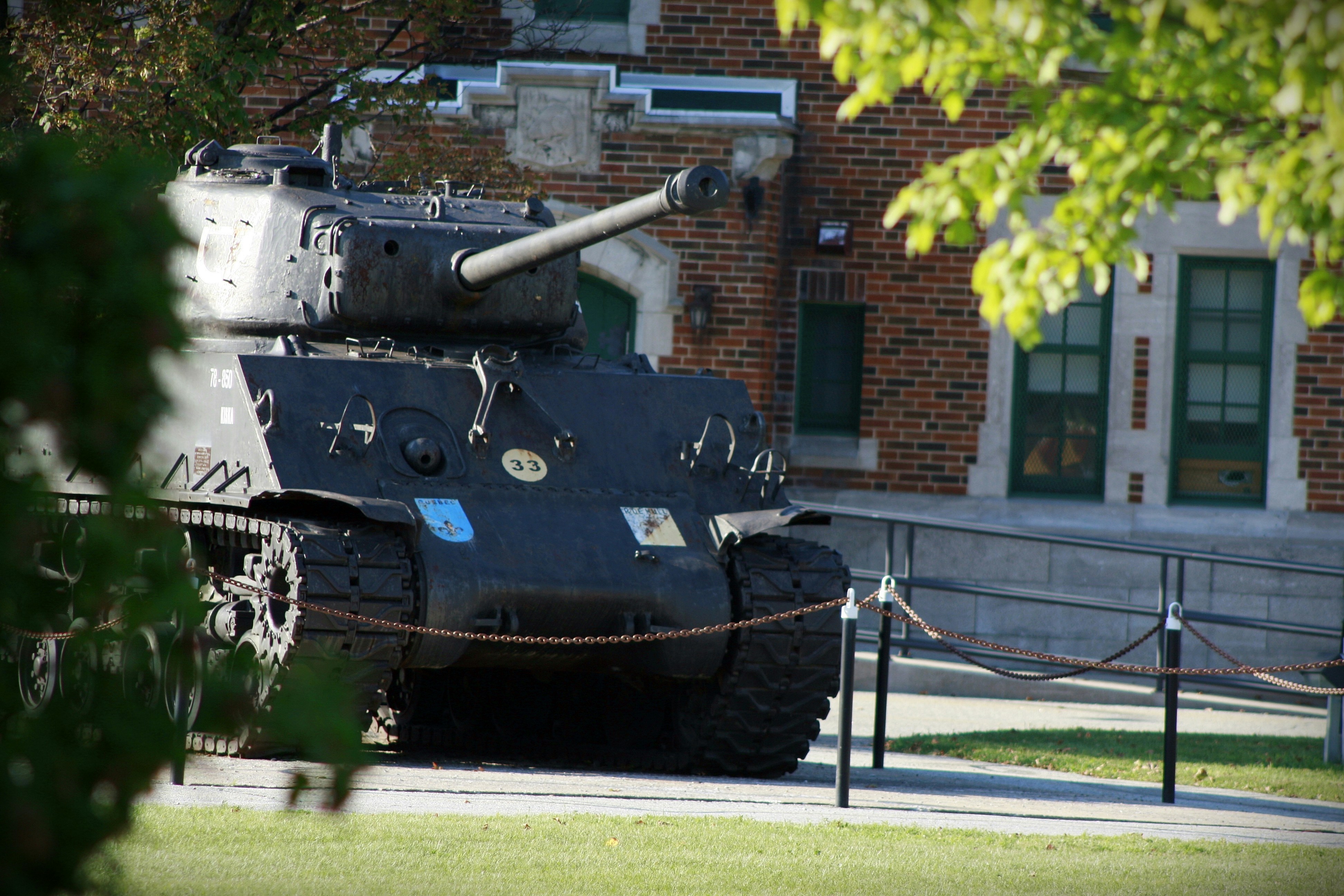 A tank stands in front of a building.