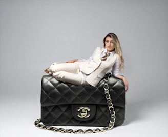 Woman poses with a large chanel handbag.