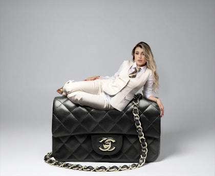 Woman poses with a large chanel handbag.