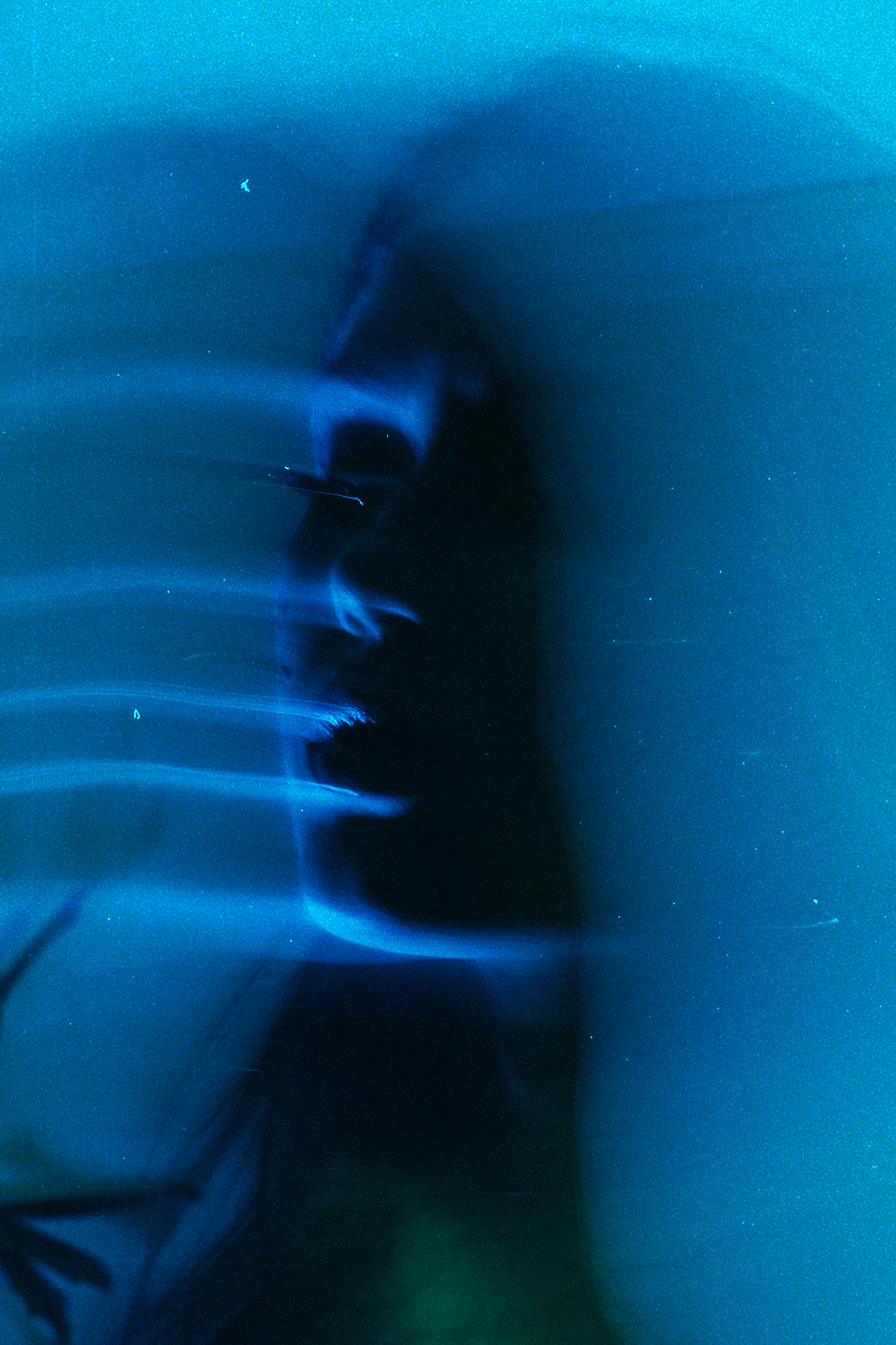 Dark silhouette with blue light streaks.