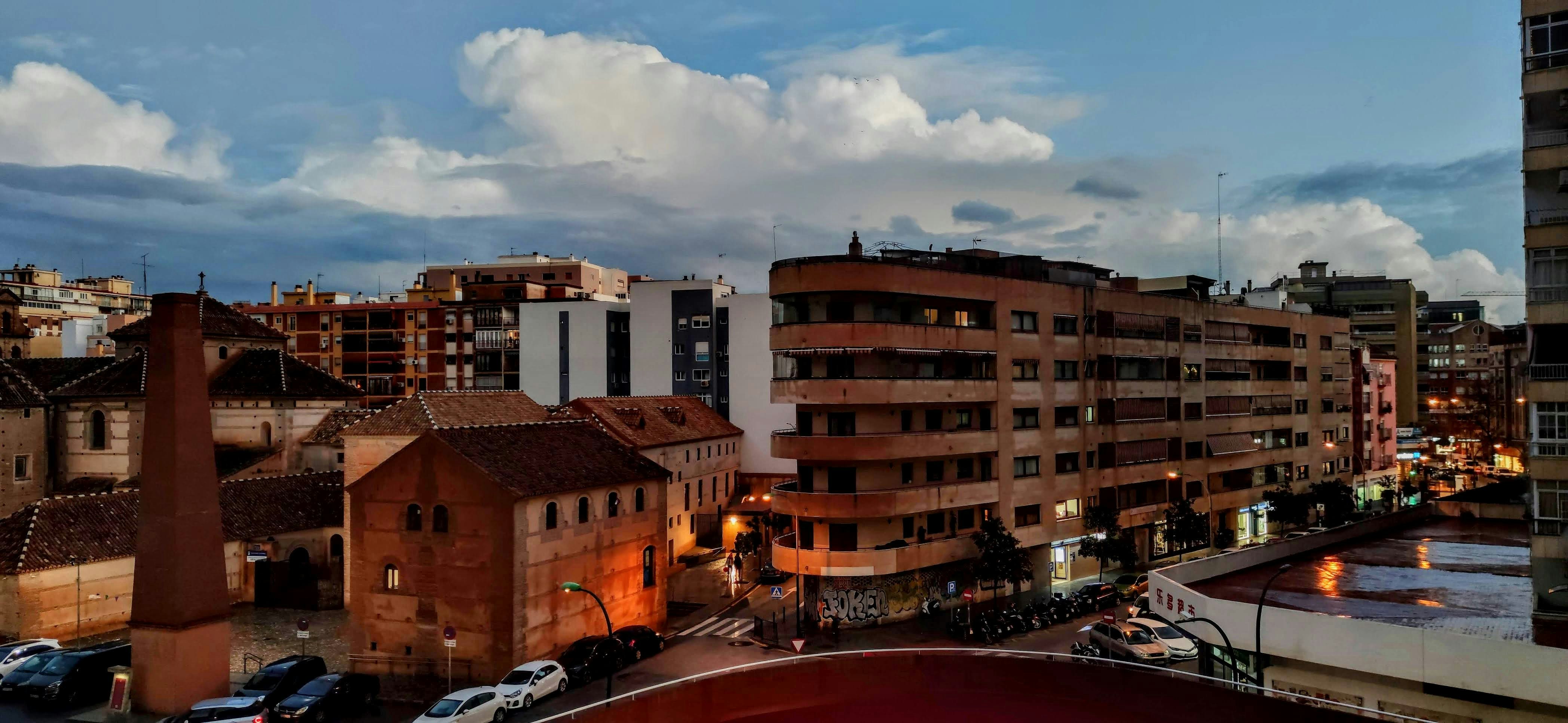 Cityscape at dusk with cloudy sky.