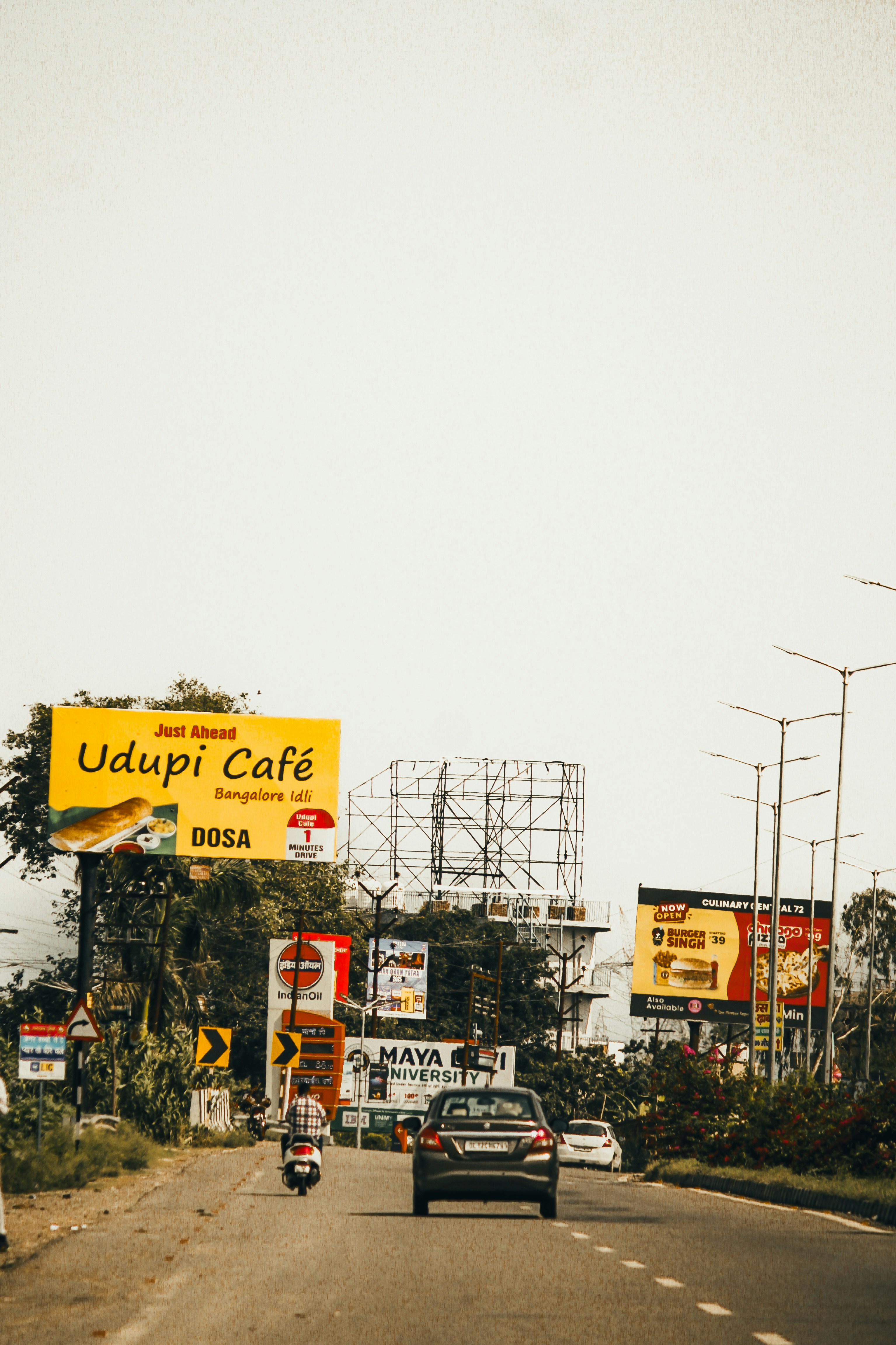 A road filled with billboards and traffic.