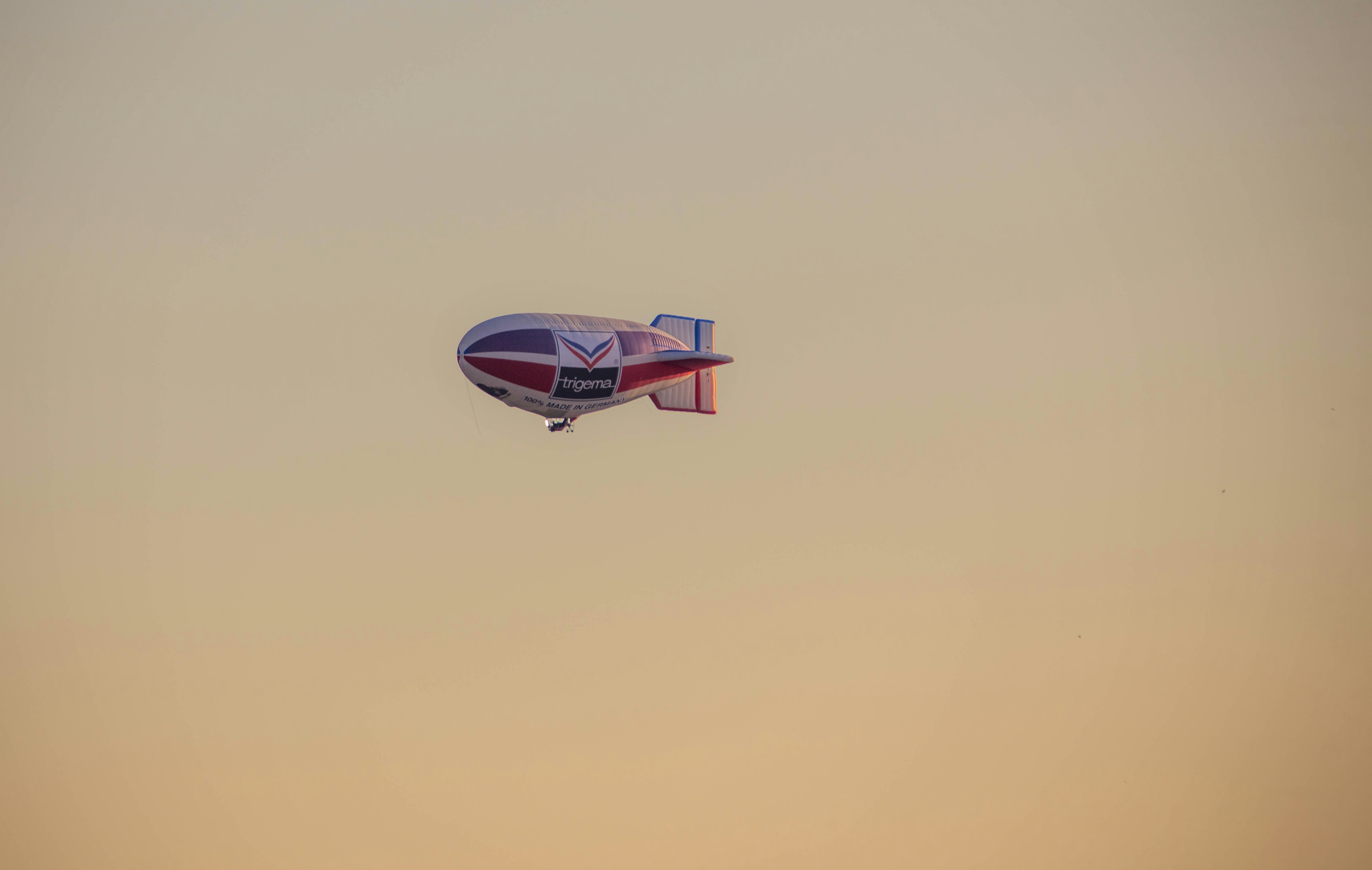 A blimp floats high in the sky.