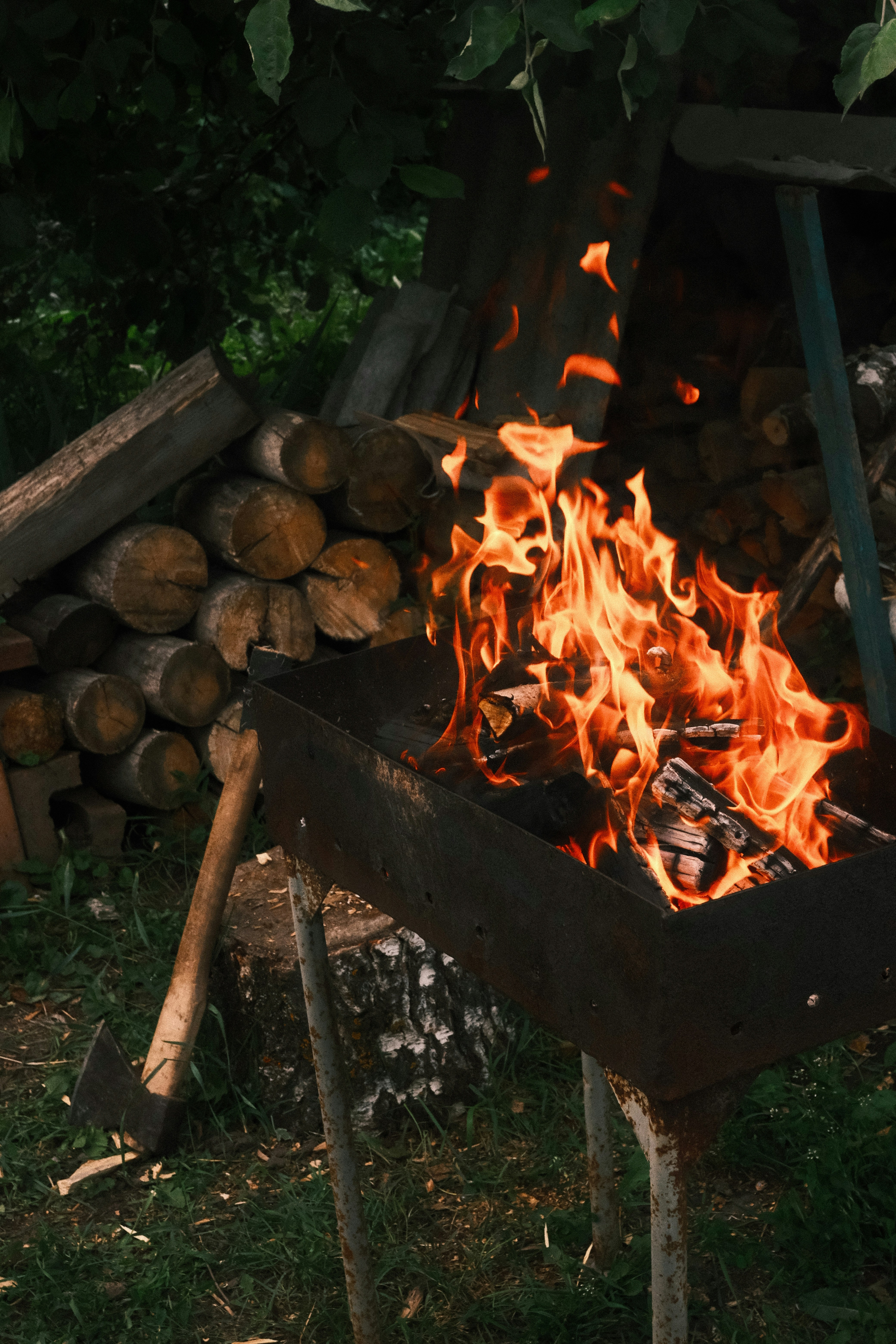 Il fuoco brucia brillantemente in una griglia con legna da ardere.