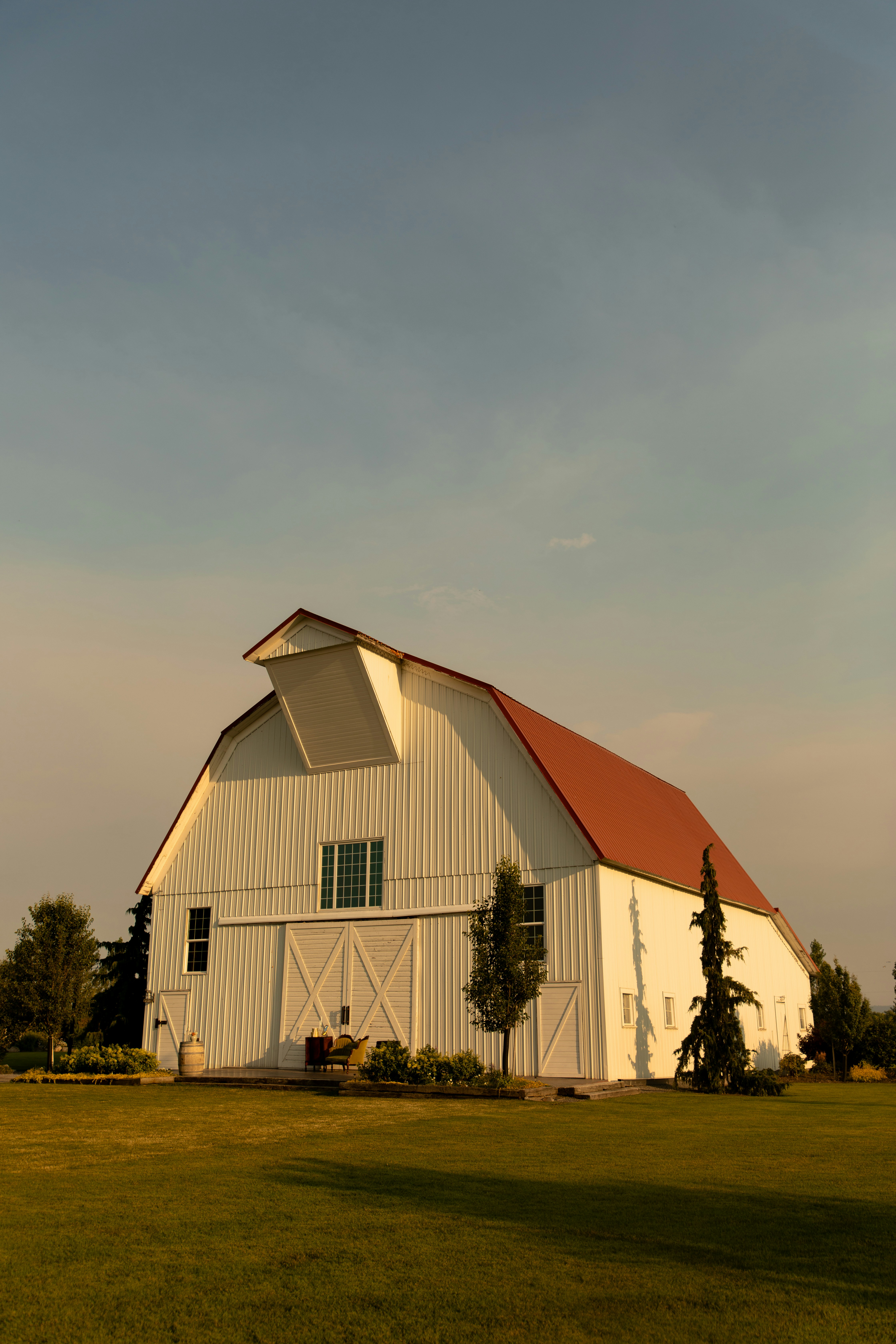 A white barn stands in a field.