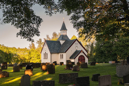 A church surrounded by gravestones and trees.