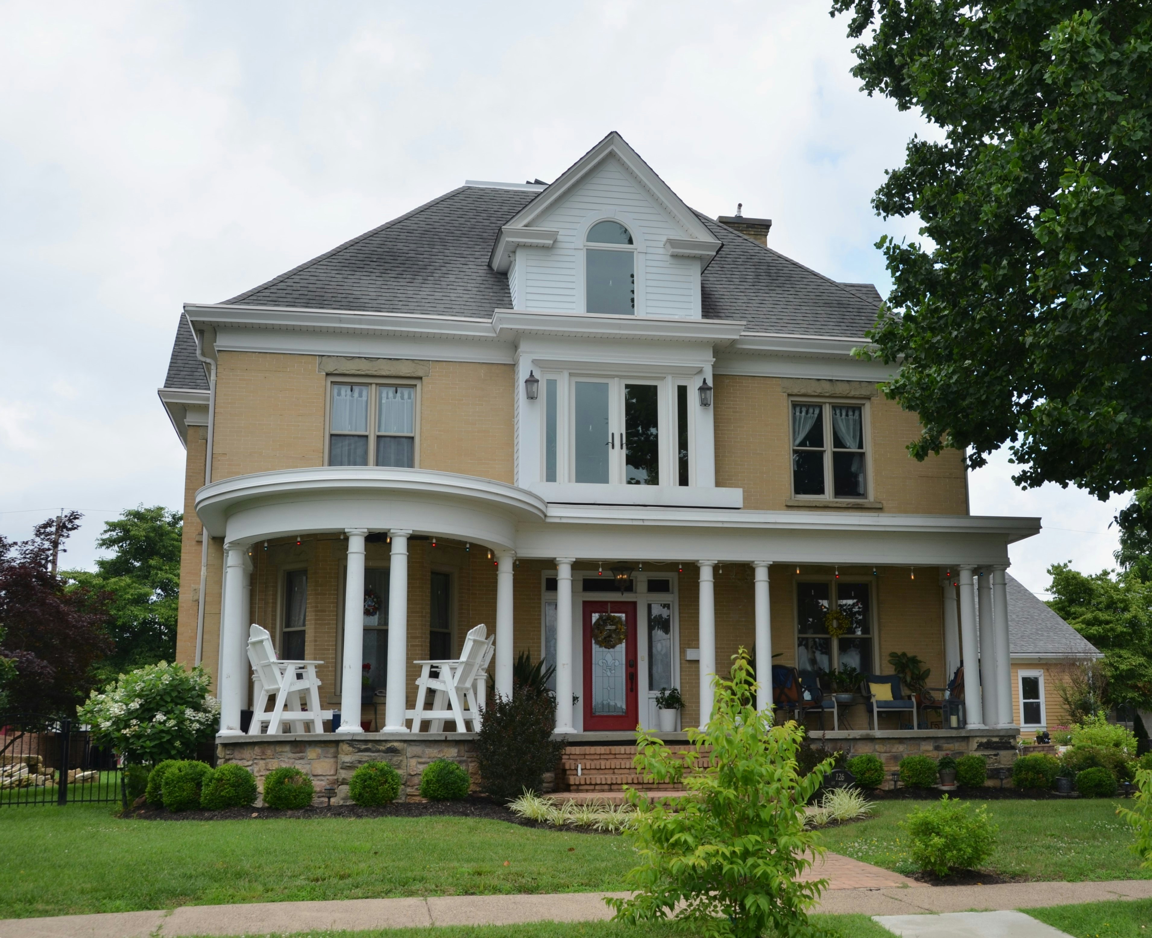 A stately, two-story house with a large porch.