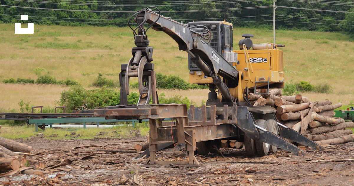 Logging Macine A logging machine is loading logs in a field. photo – Free Wood Image ...