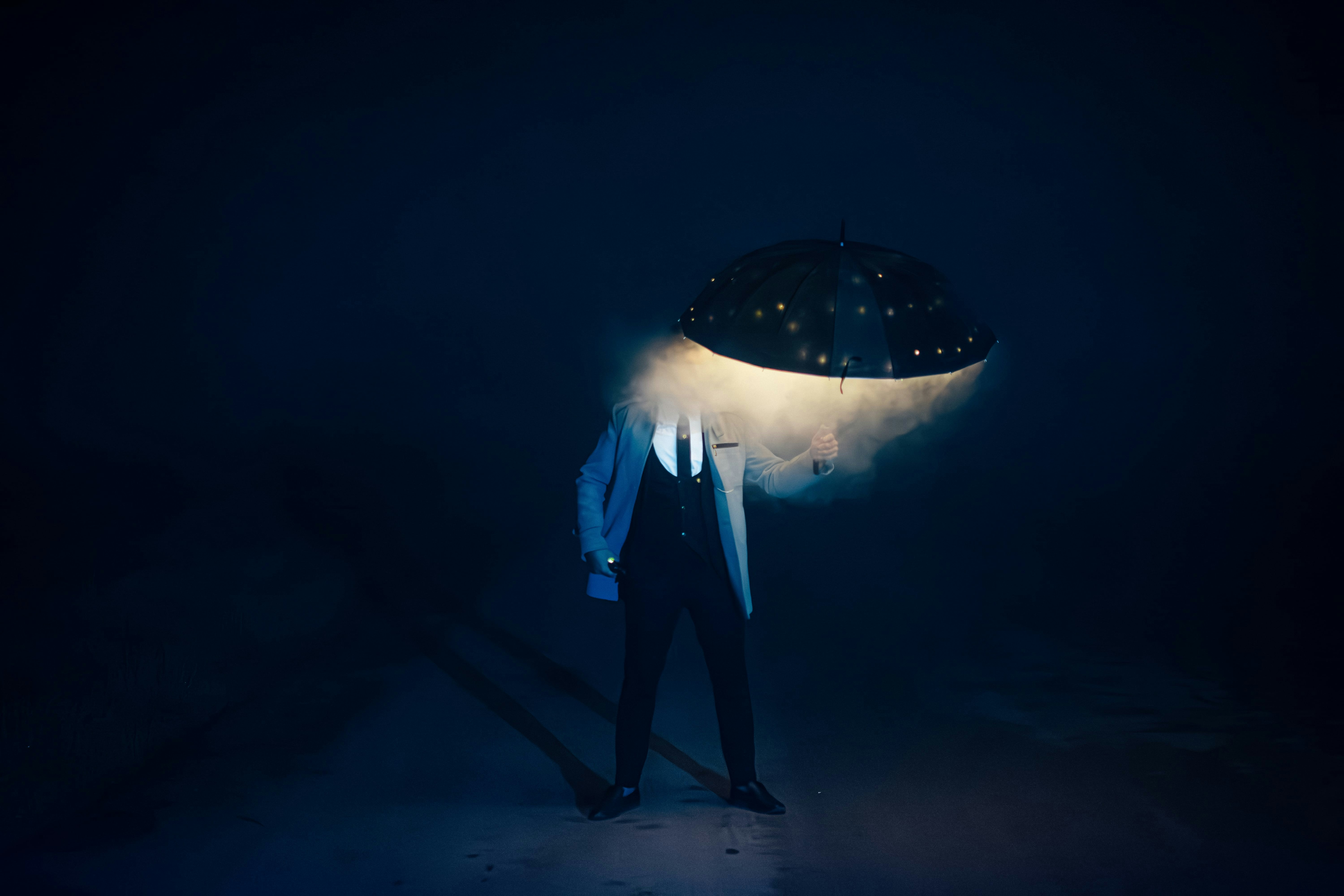 A man stands with an umbrella-like head.