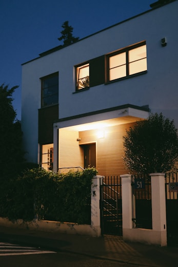 A modern house illuminated at twilight.