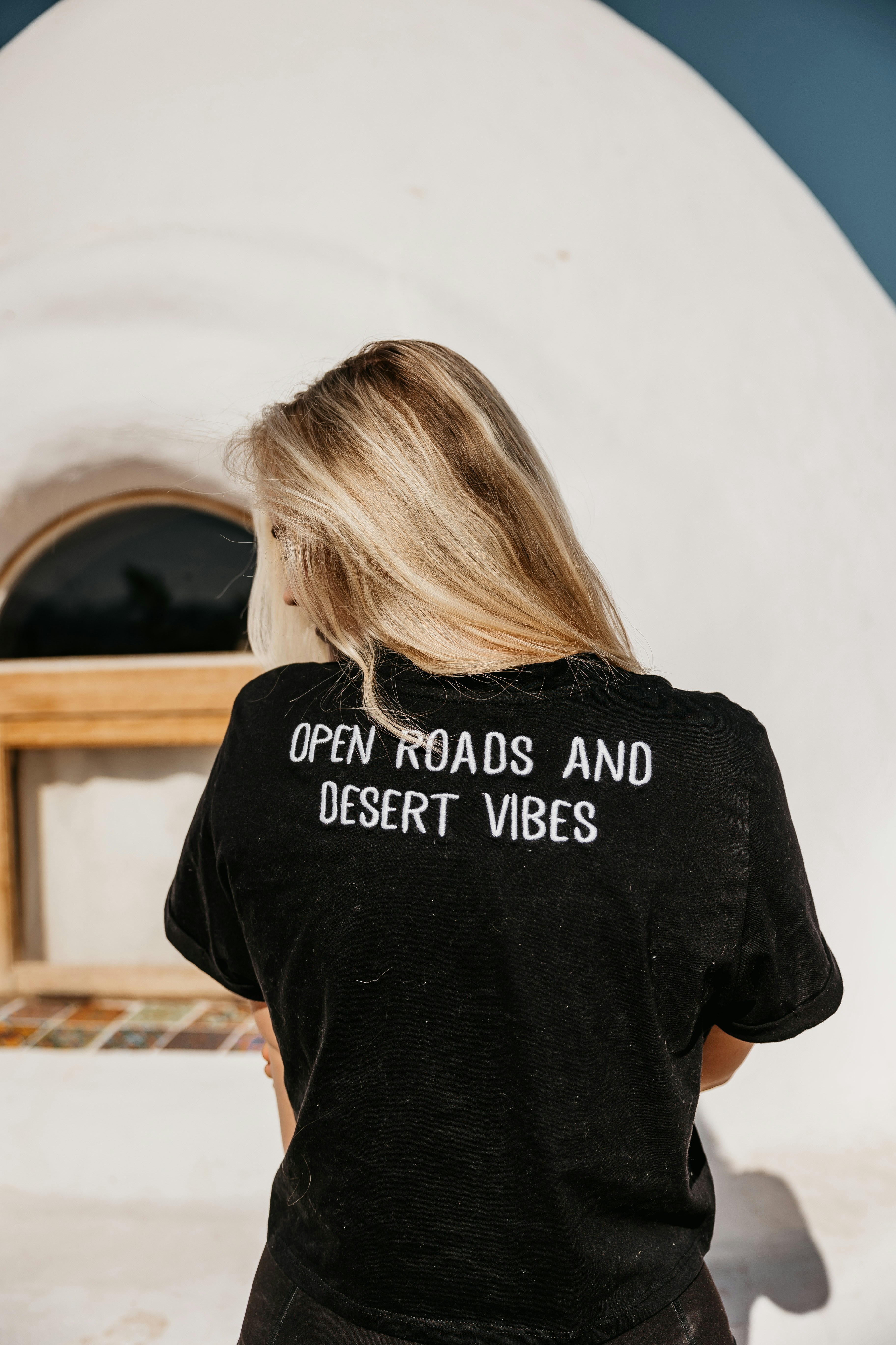 Blonde woman wearing a shirt with text on the back