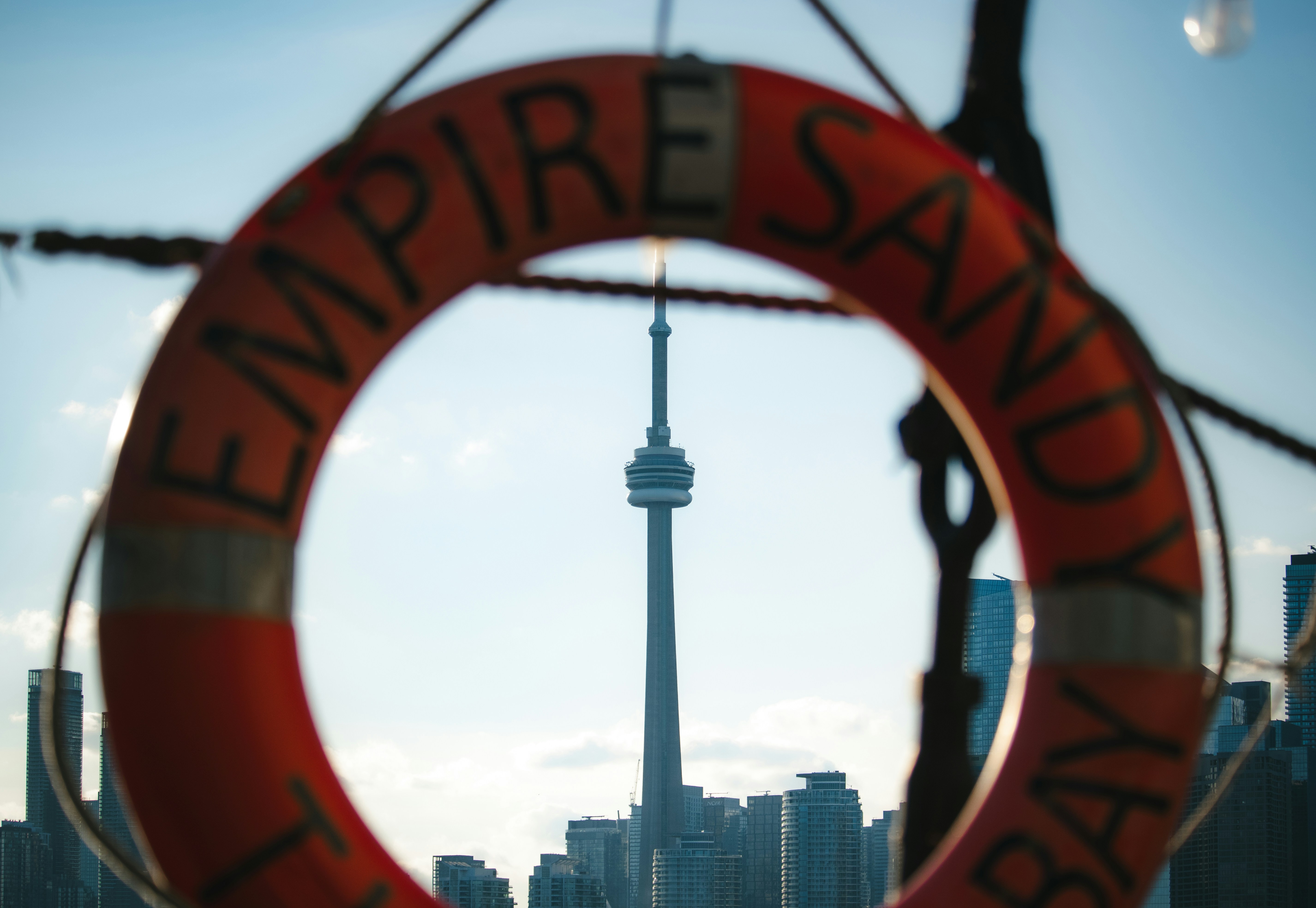 A shot of the CN Tower through a life ring on a ship.