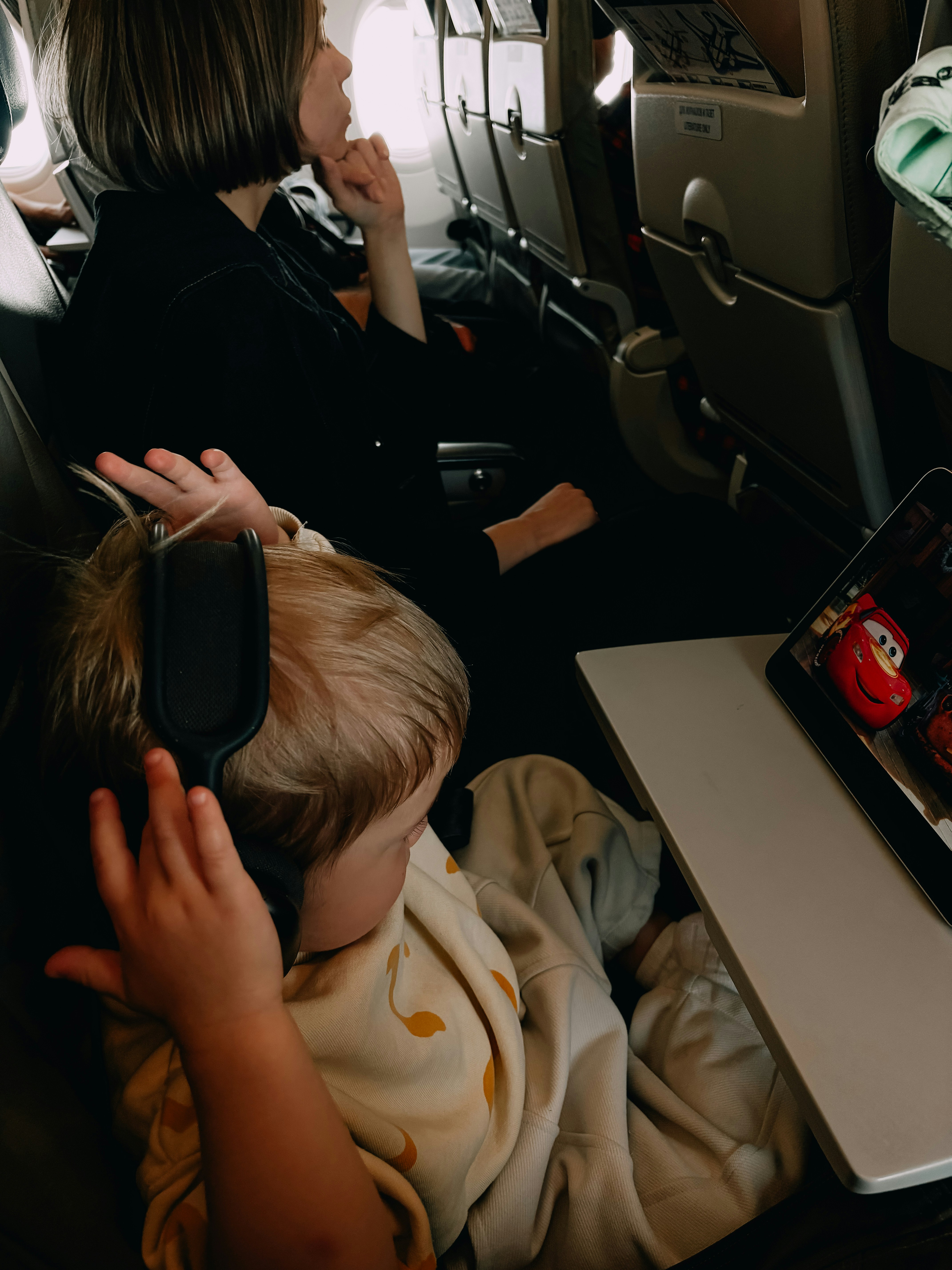 A child watches a movie on a plane.